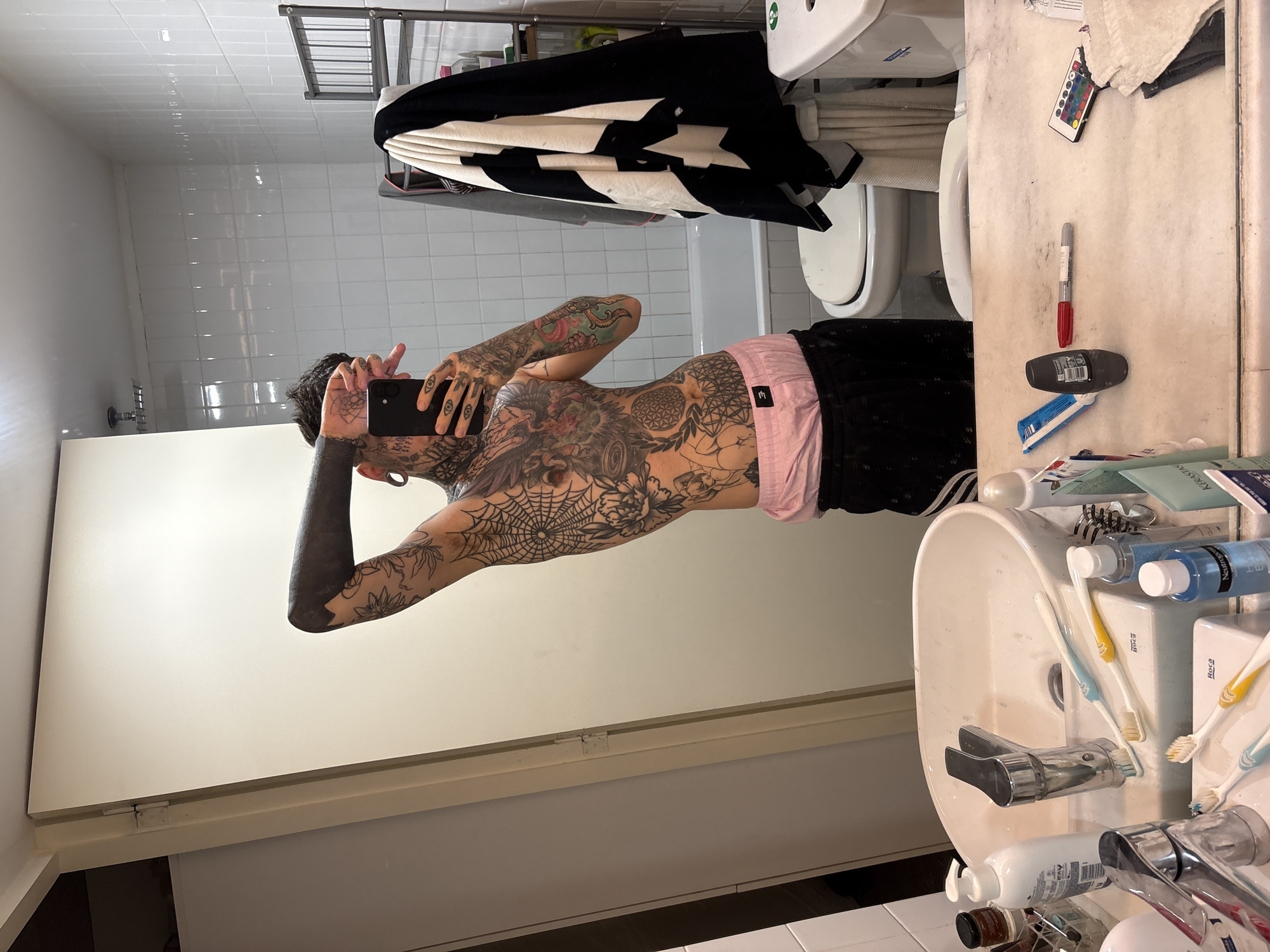 Tattooed individual takes multiple selfies in Buenos Aires residence