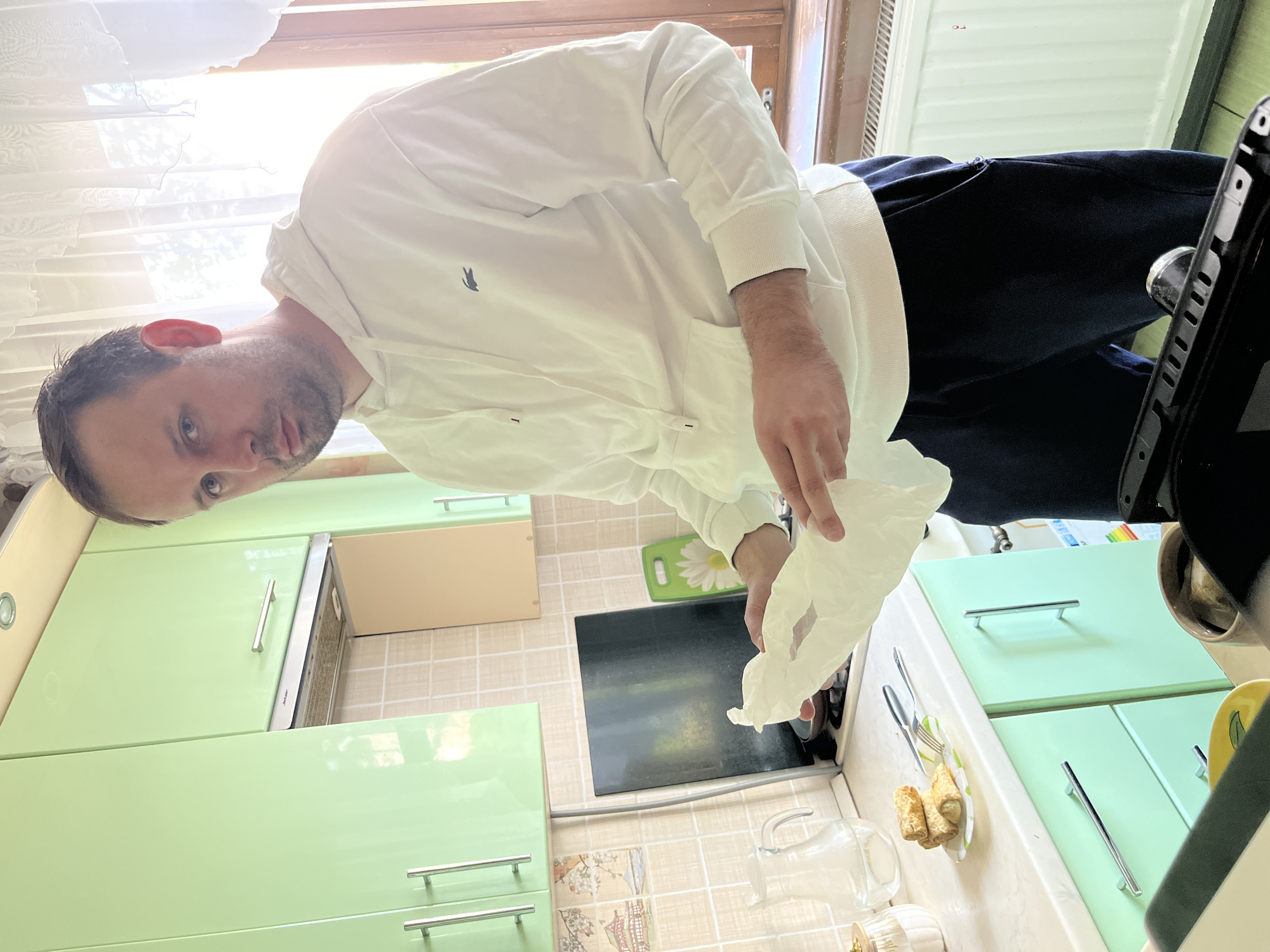 Man with paper observed in kitchen, Rusanovo, Russia