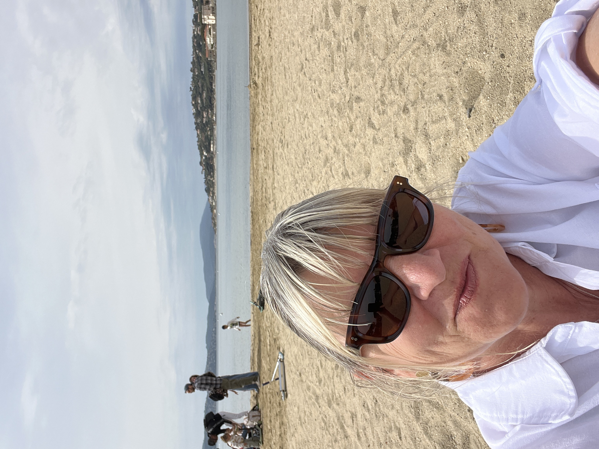 Women relax on Sainte-Maxime beach during overcast morning