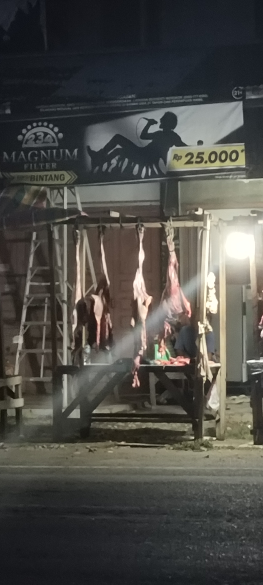 Nighttime meat vendor operates roadside stall in Lhokseumawe