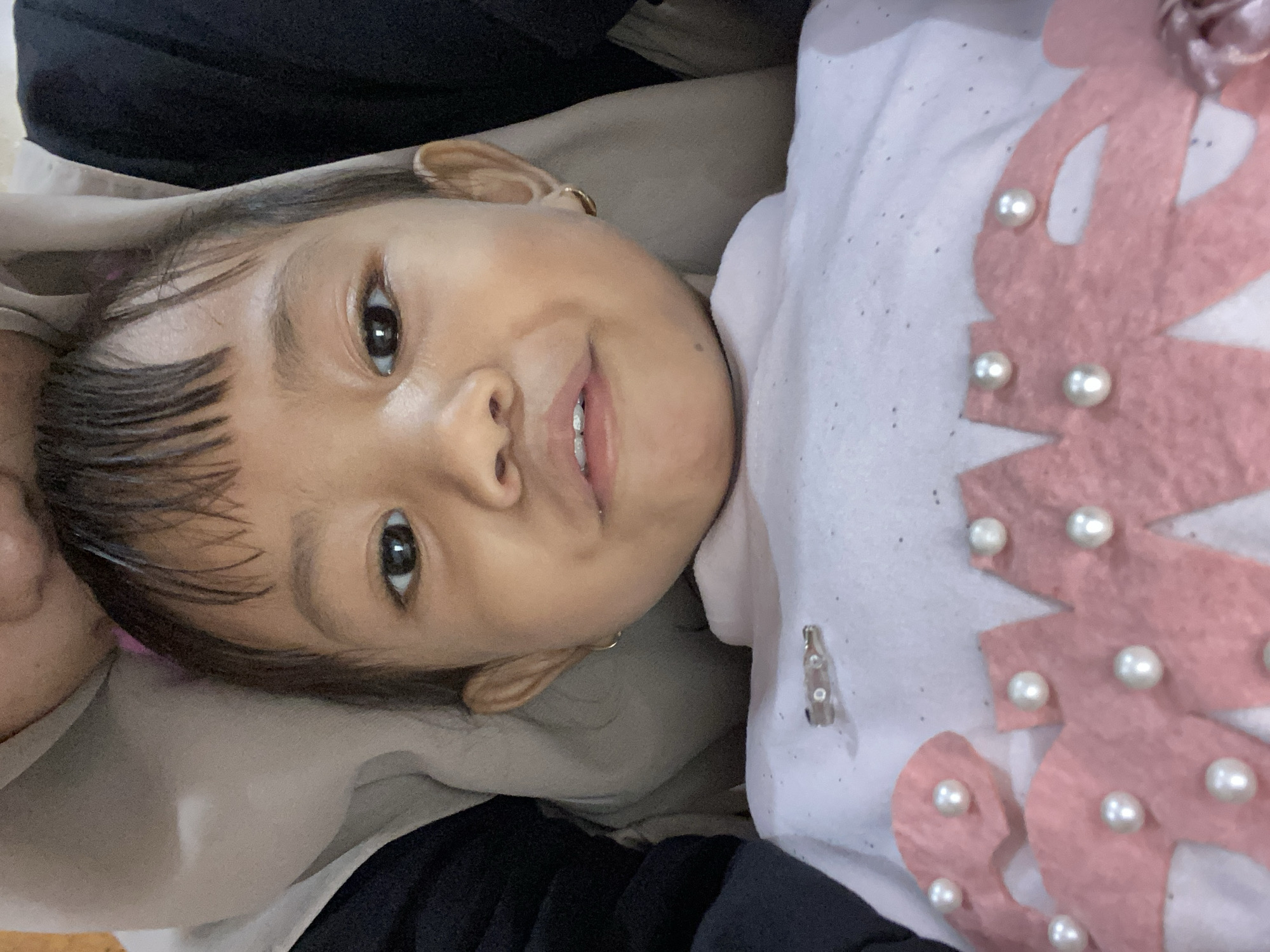 Kid with pink bows photographed around a workshop in Ta', Indonesia