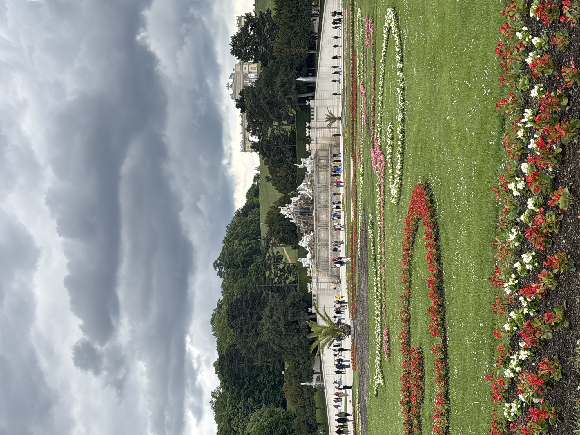Visitors explore Schönbrunn Palace gardens on cloudy Vienna morning