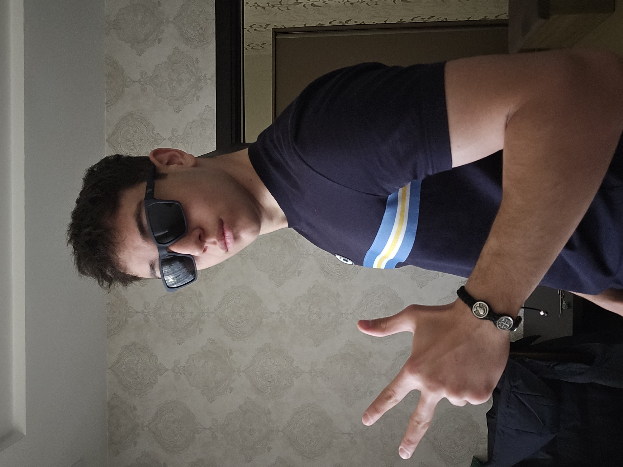 Young man poses indoors in Yerevan wearing striped shirt