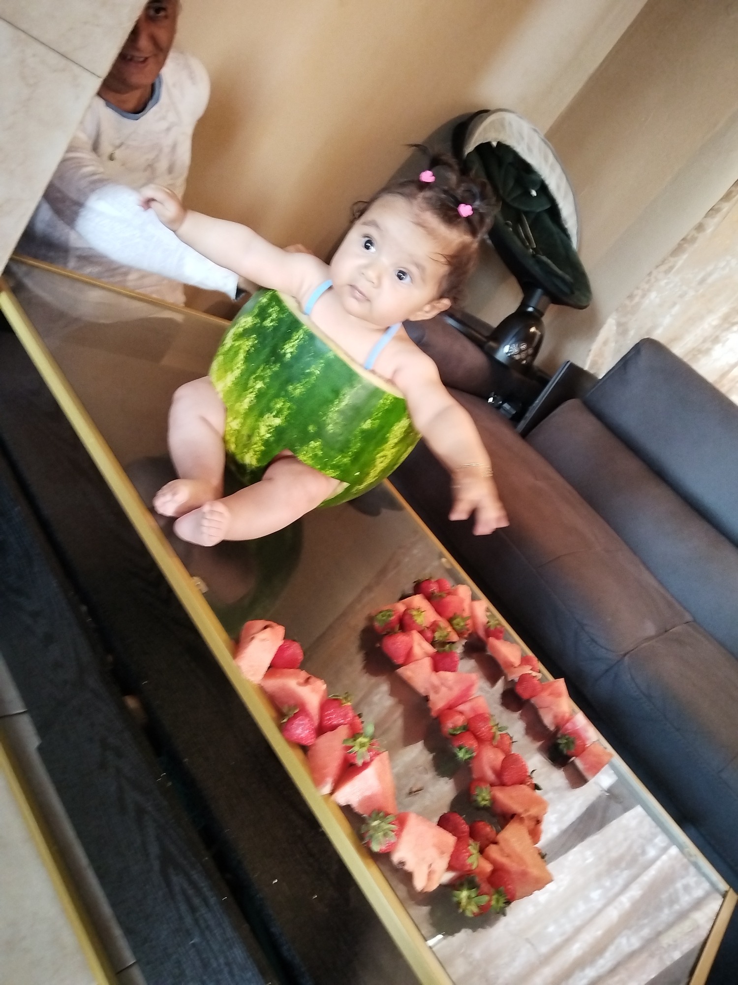 Baby photographed in watermelon costume and stroller during morning