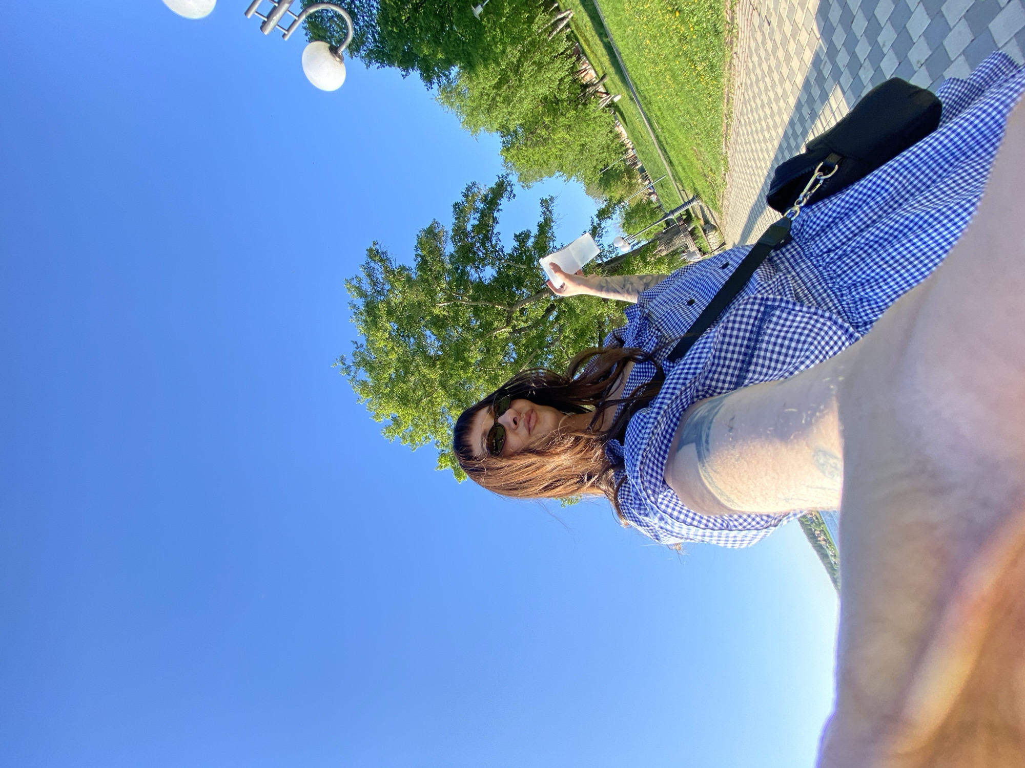 Woman enjoys cold drink during sunny park outing in Votkinsk