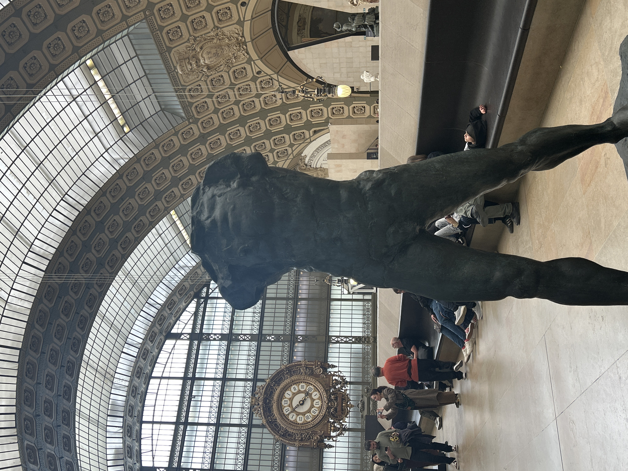 Visitor documents sculptures, ceiling art at Paris Musée d'Orsay