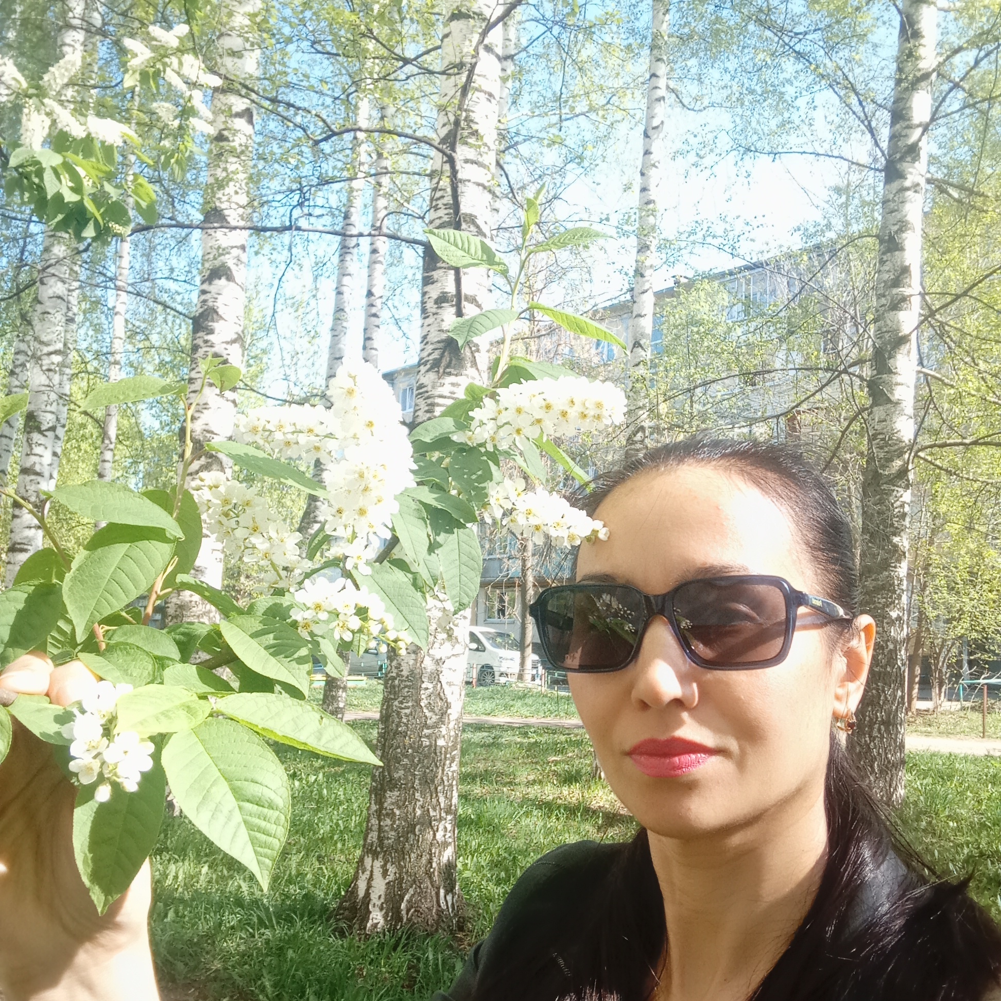 Woman holds flowering branch in Izhevsk park