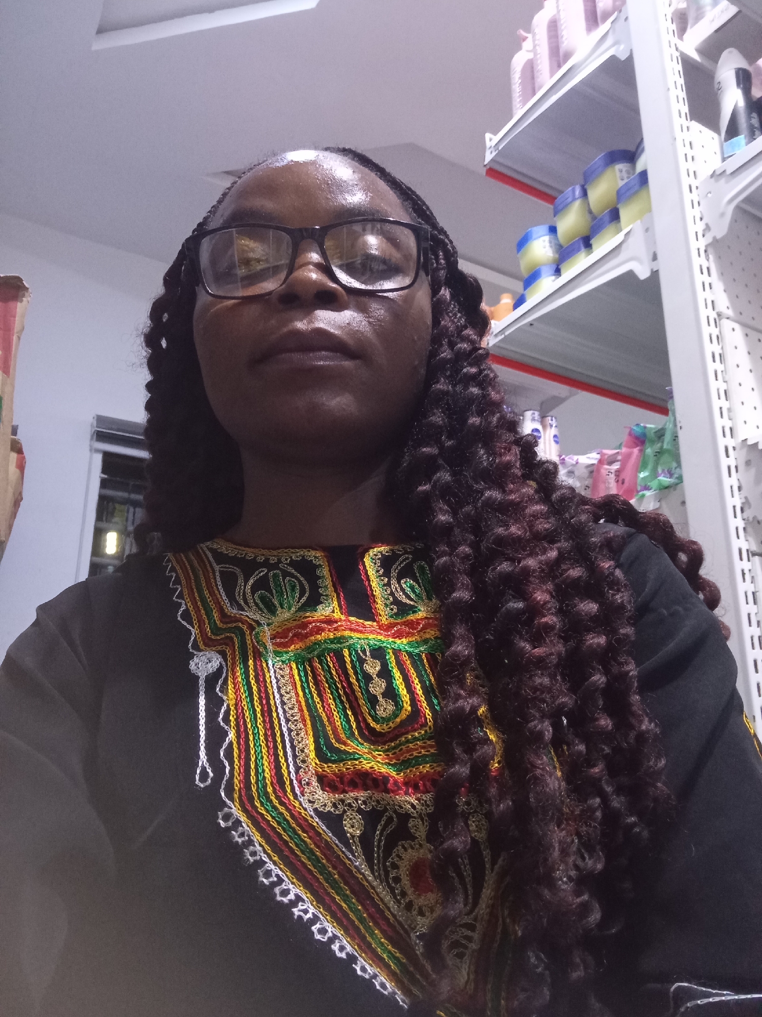 Selfie session in a Nigerian retail store, colorful embroidered top