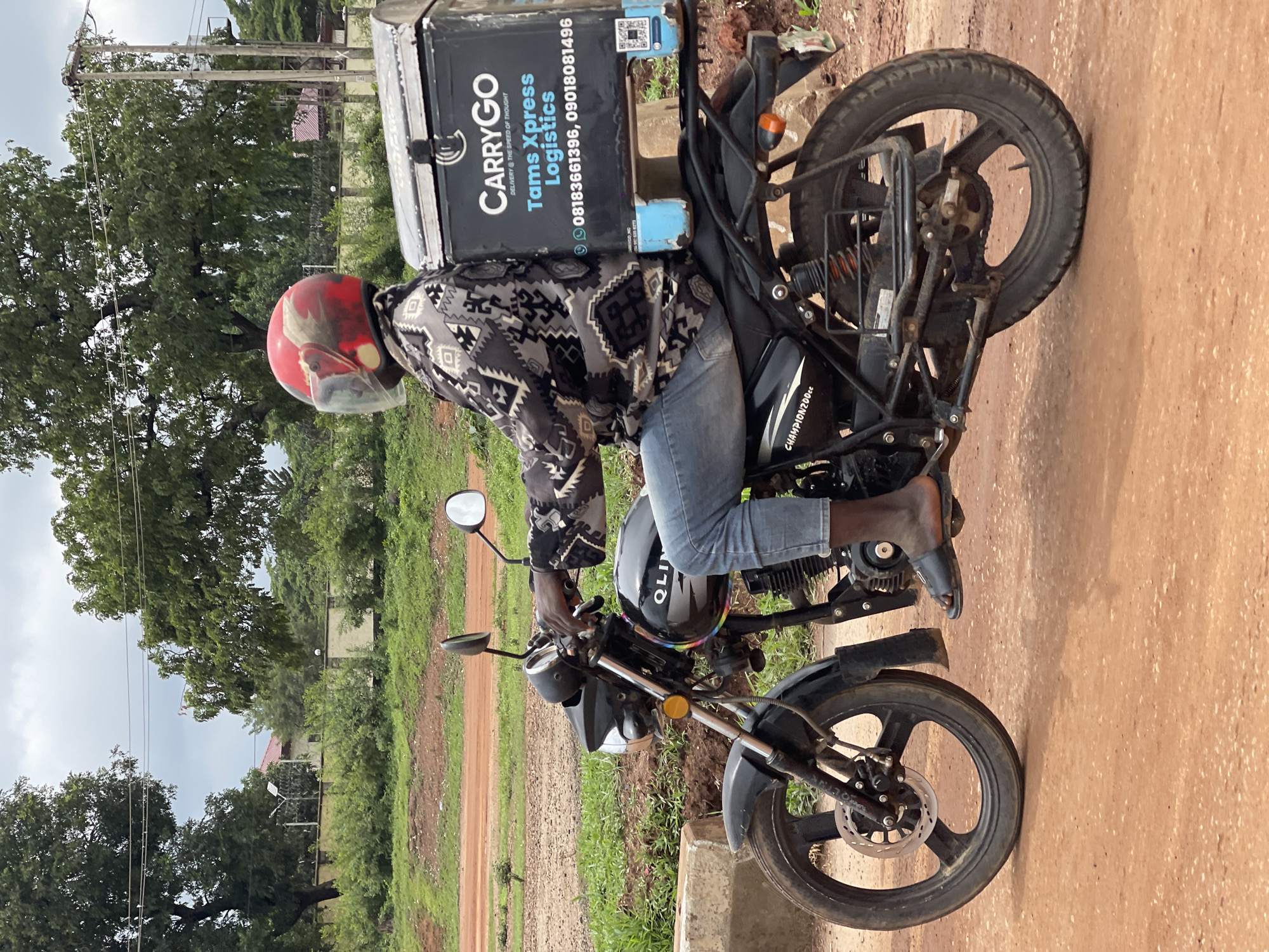 Motorcycle rider in red helmet on Abuja streets