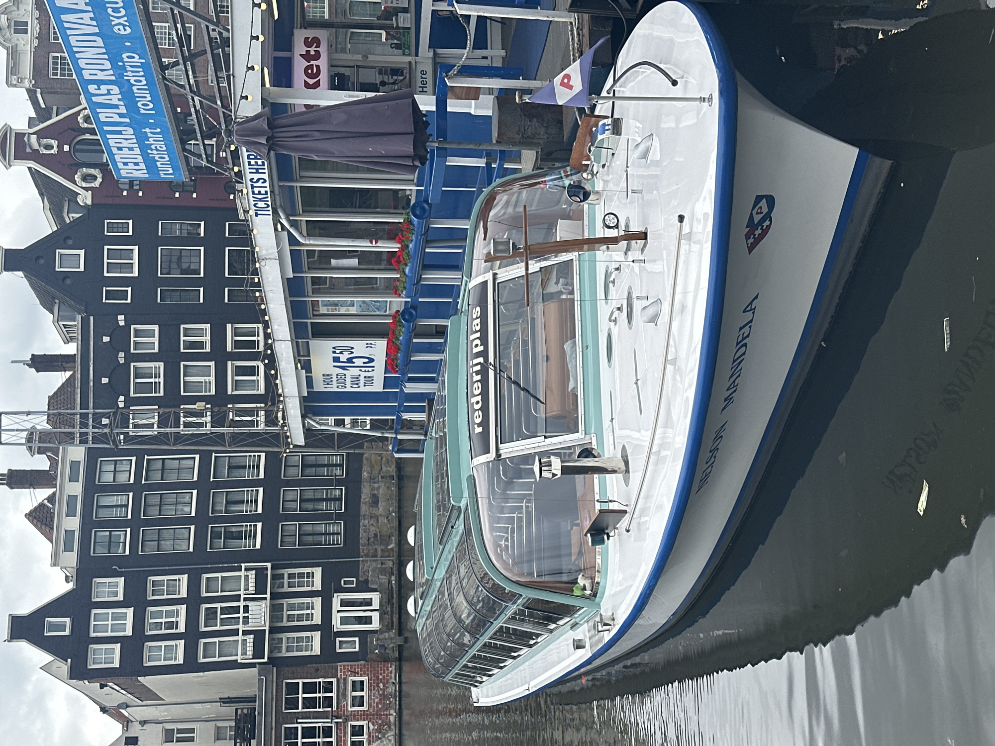 Two glass-roofed canal boats docked in Amsterdam