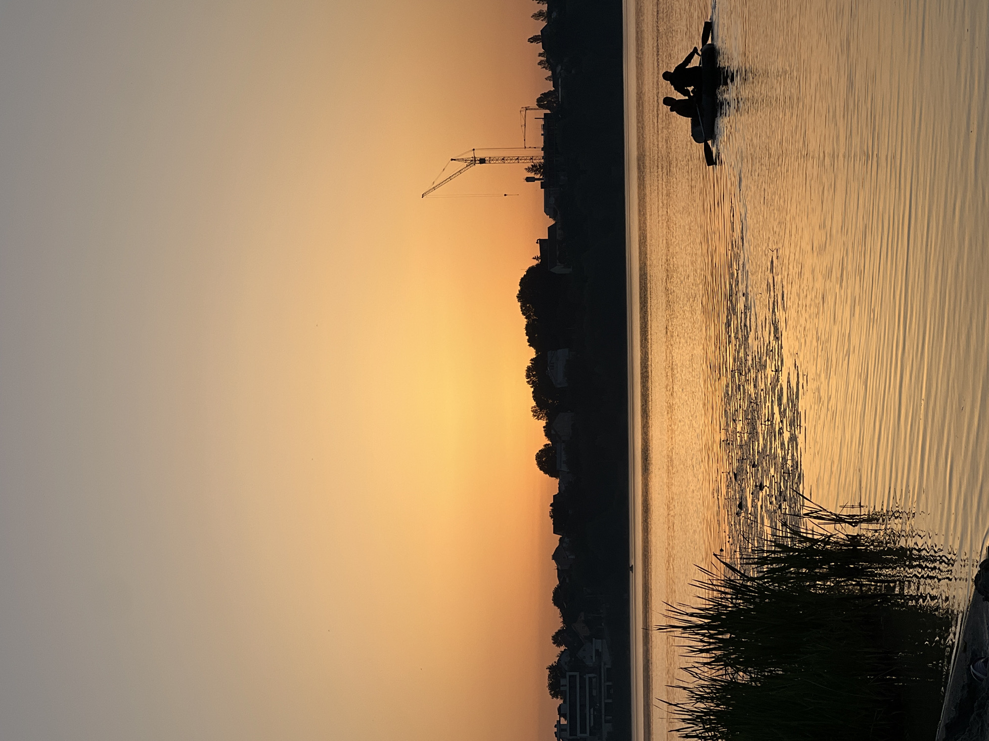 Golden sunset at Ternopil Pond, figure wading in the shallows