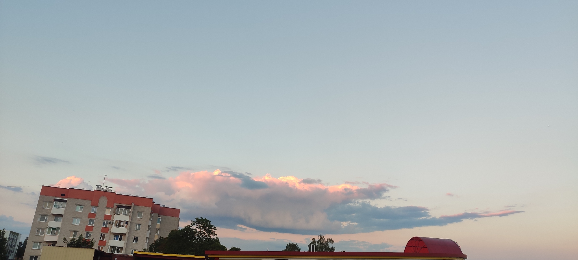 Zelva at dusk: apartment blocks and open meadows on the edge of town