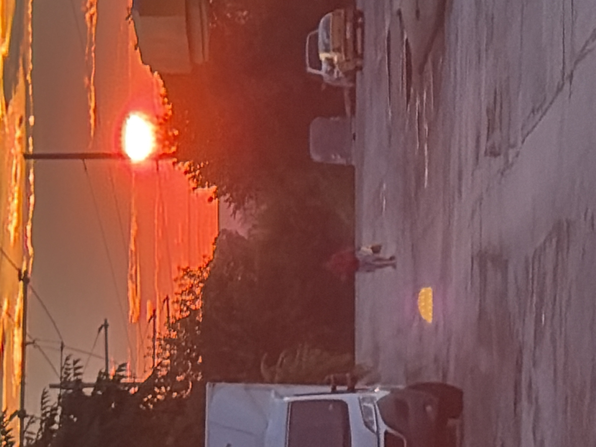 City street walk under a fiery orange sunset sky
