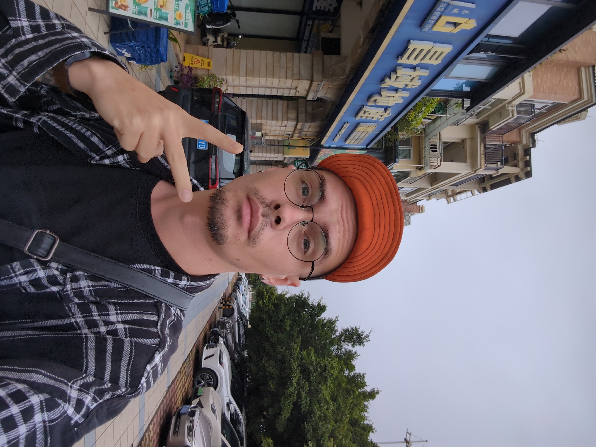 Man in orange hat takes peace sign selfie in Shunde