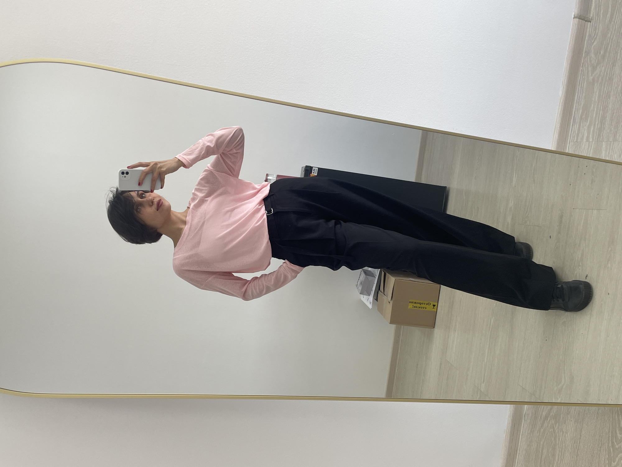 Person takes mirror selfie in Izhevsk wearing pink shirt