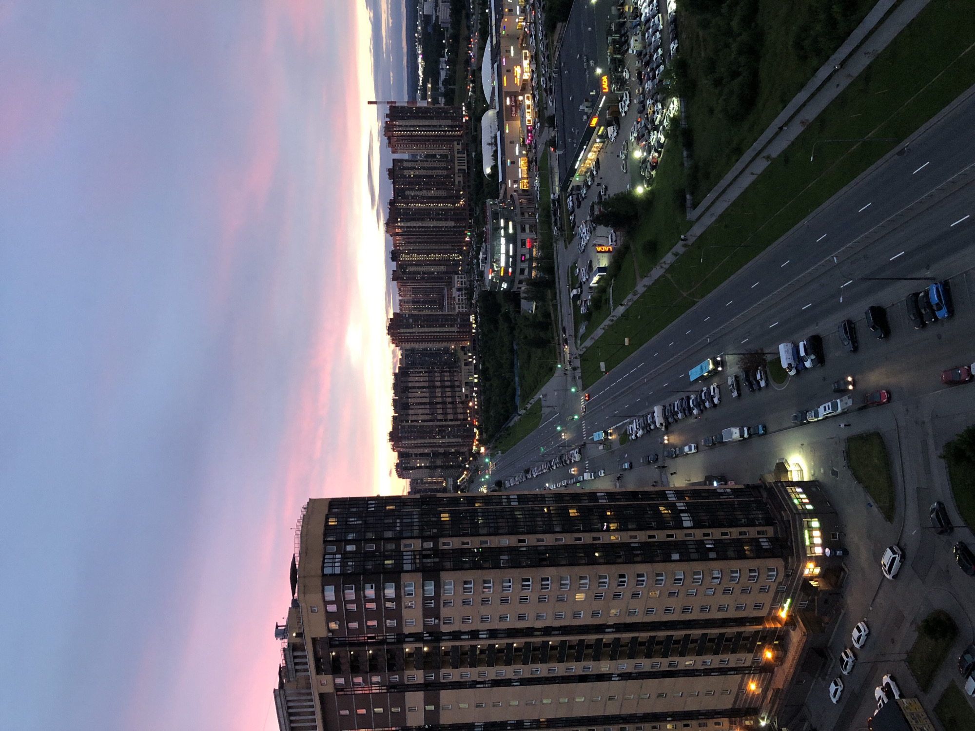 City at dusk from above, plus a cat watching from a window