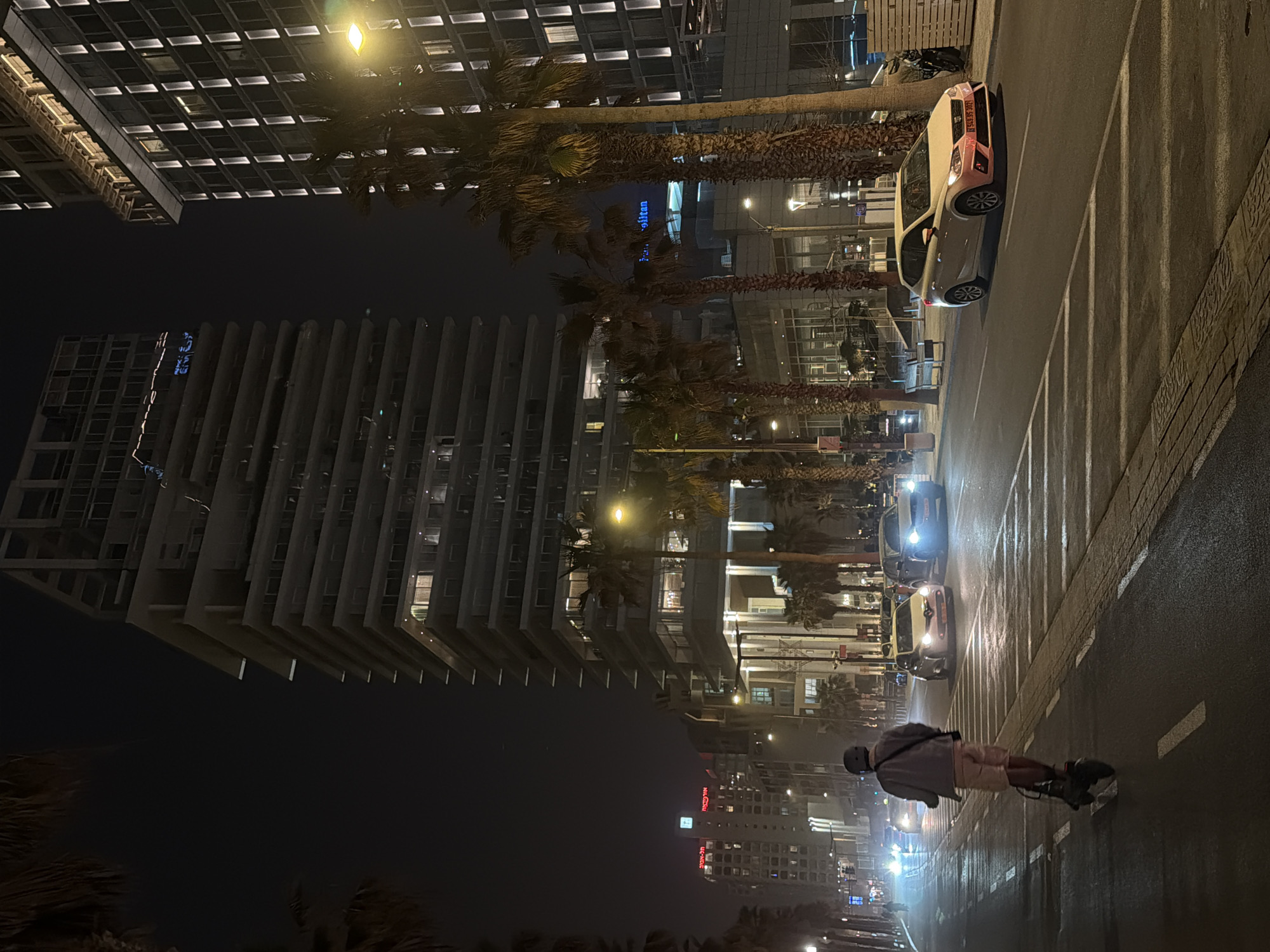 Roller skater travels streetlit Tel Aviv road at night
