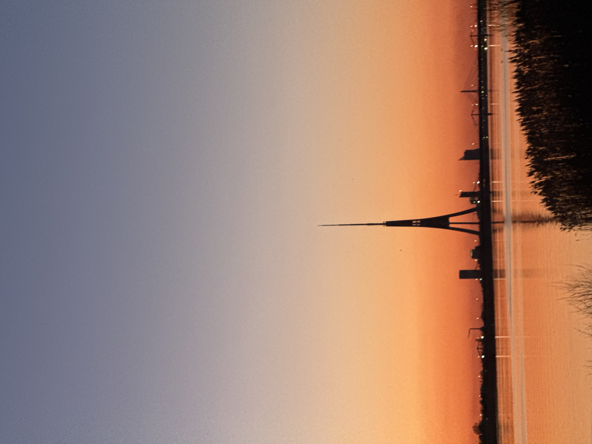 Sunset silhouettes Riga's iconic TV tower over Daugava River