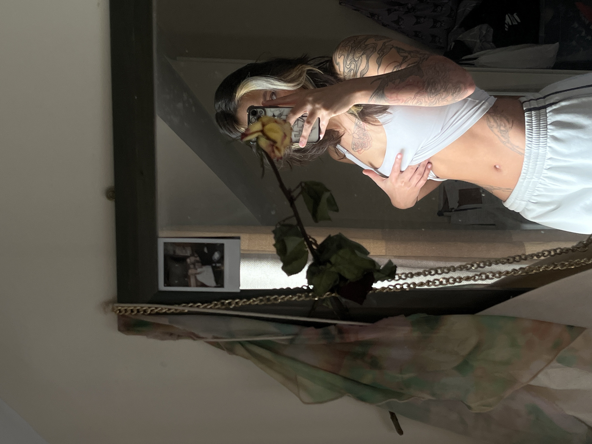 Woman takes mirror selfie with wilting rose in Tunbridge Wells
