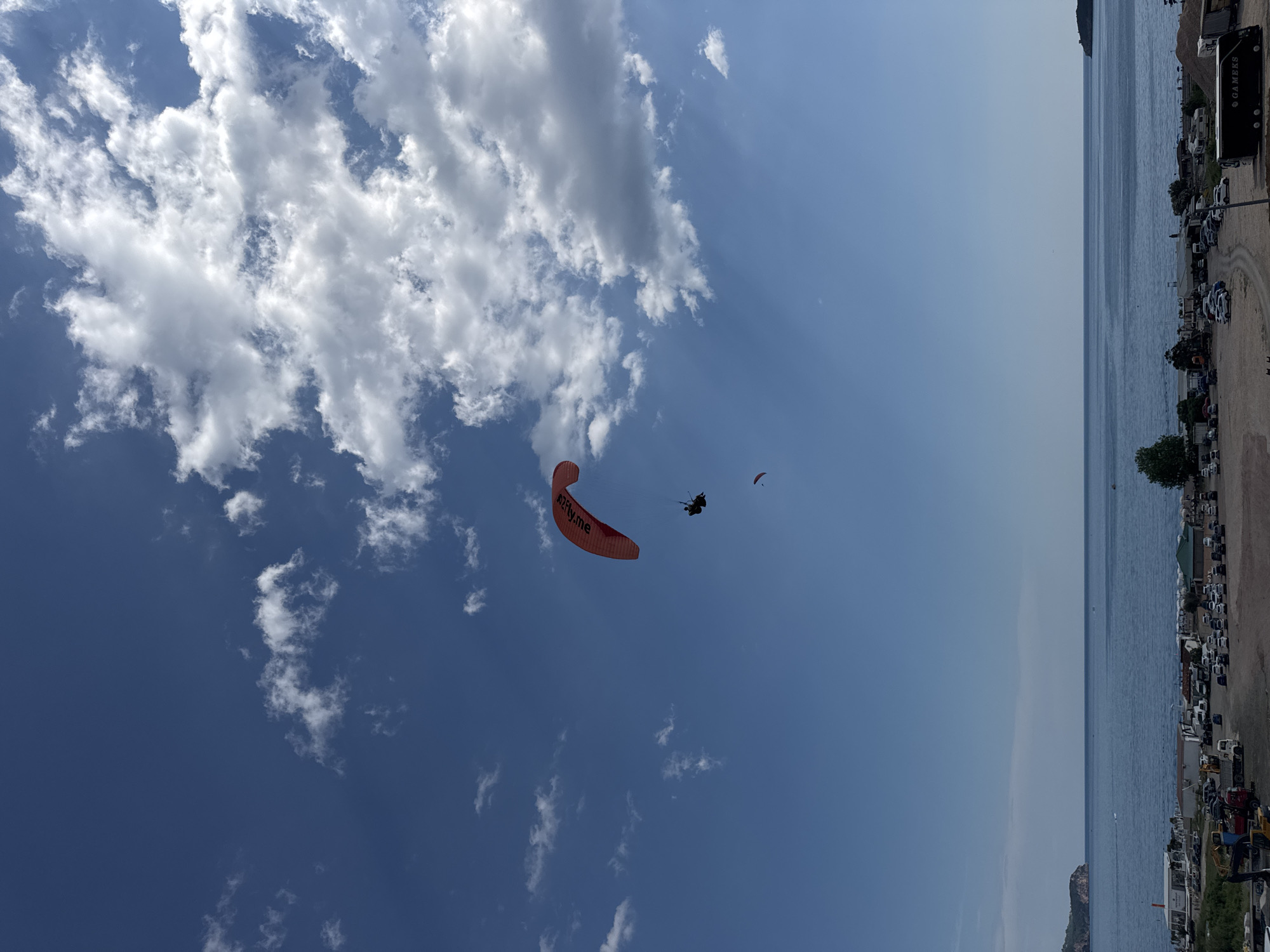 Paragliders soar over Montenegro coast during afternoon leisure hours