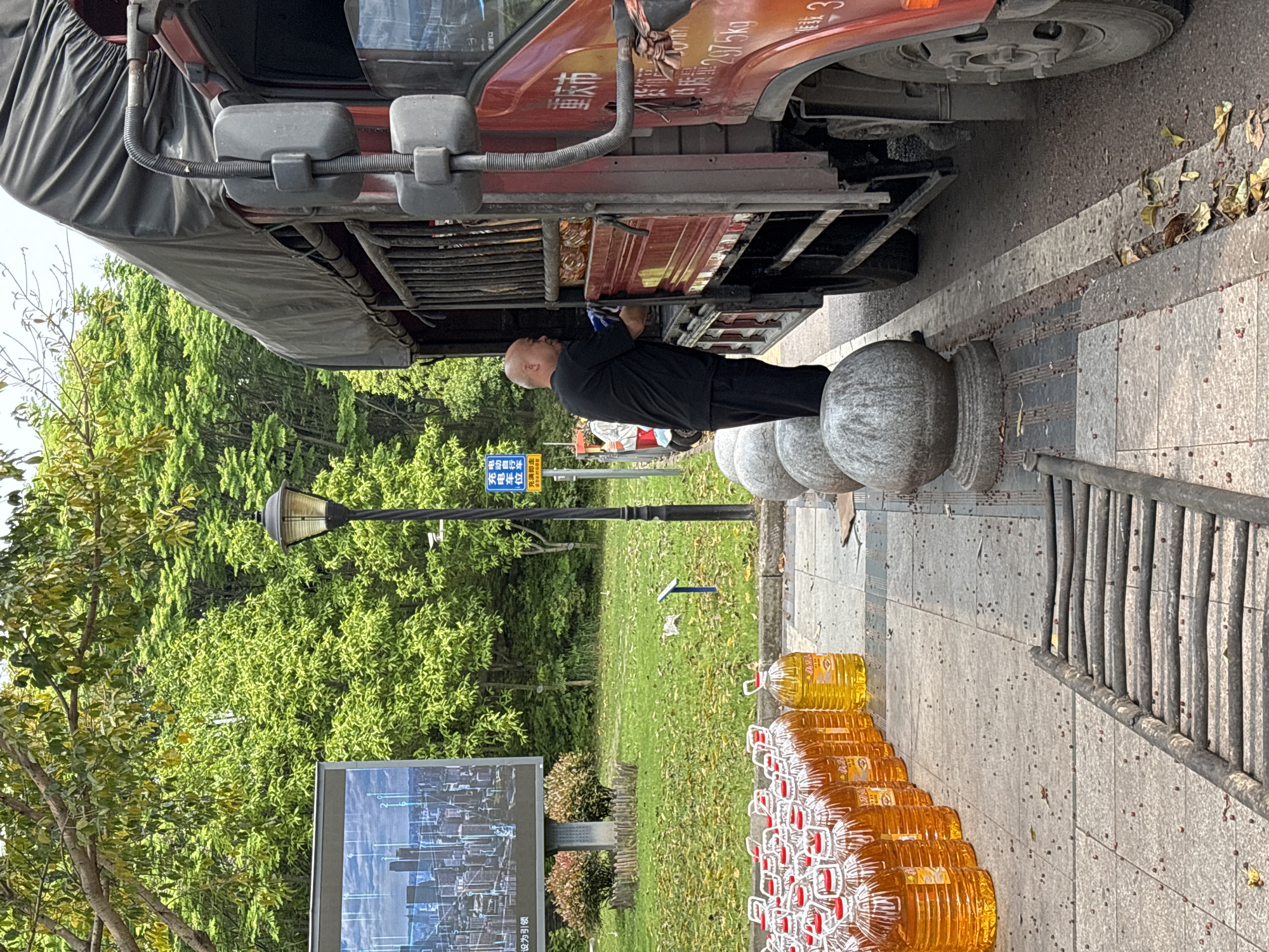 Man repairs red truck on sidewalk in Jiangjin