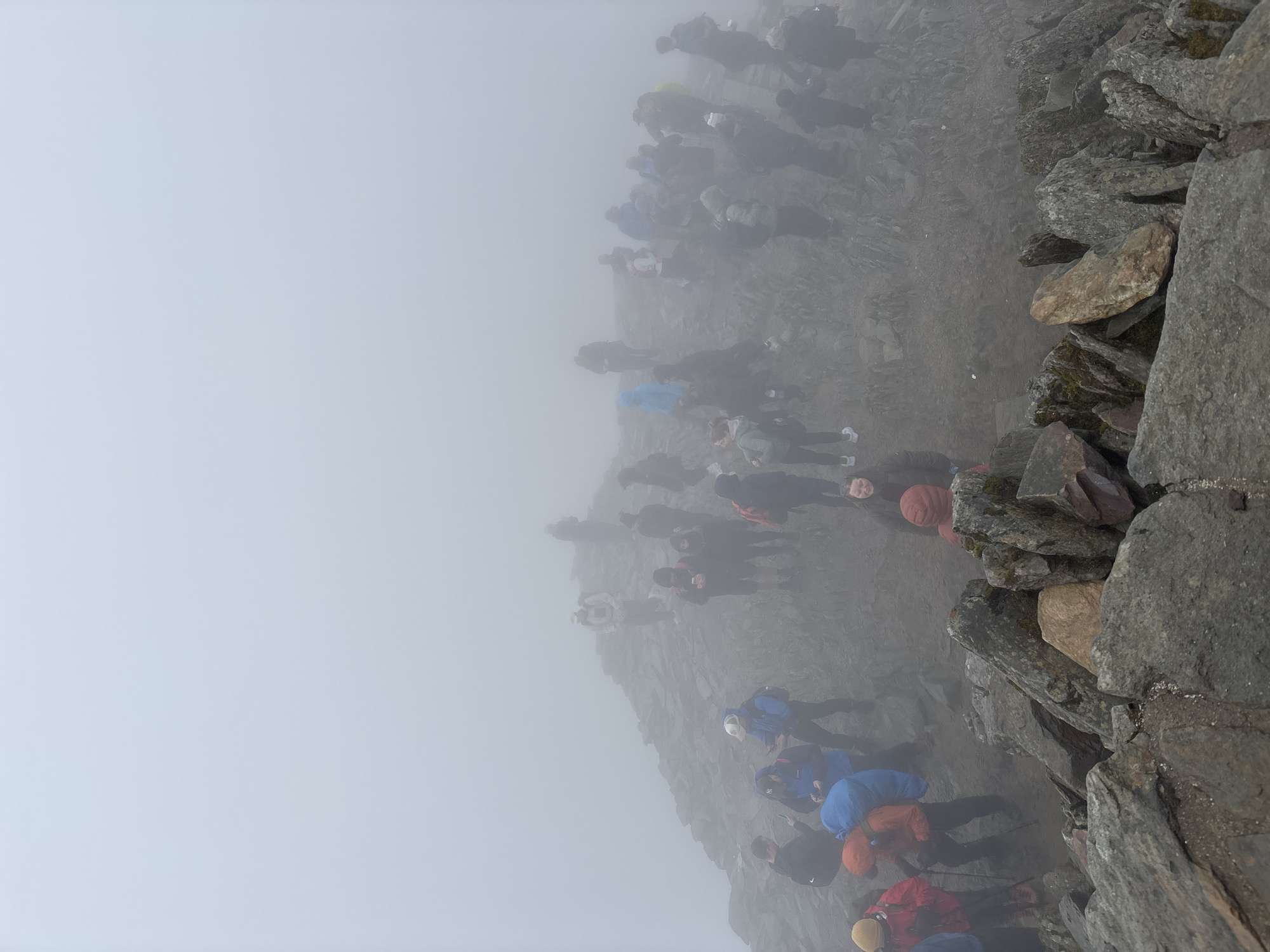 Hikers navigate foggy mountain paths near Beddgelert, Wales