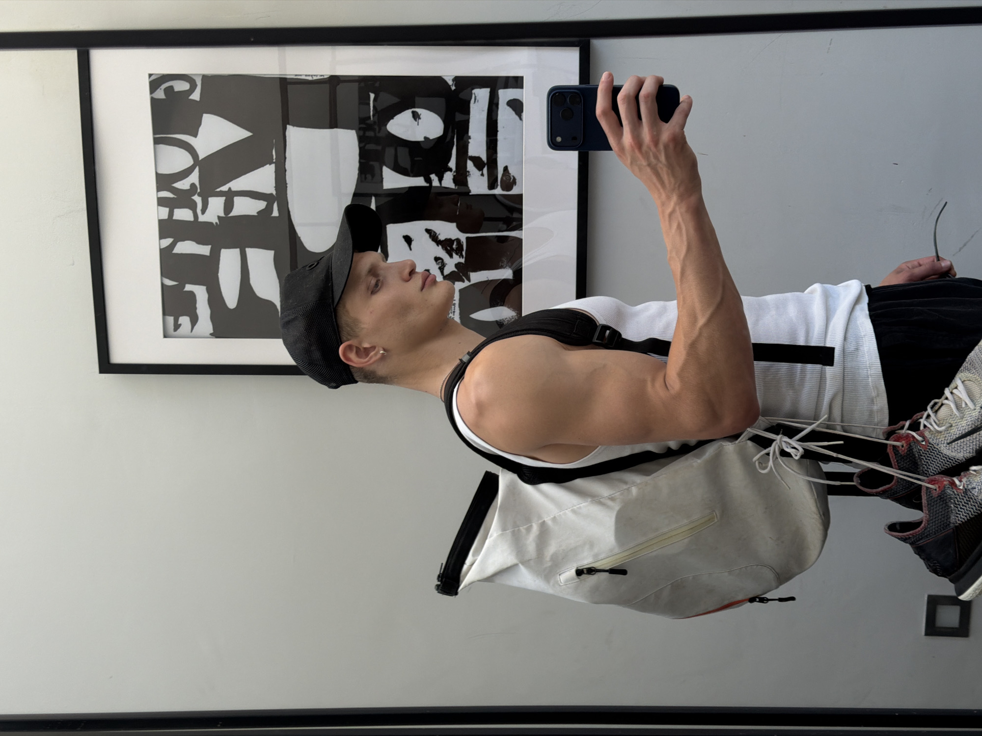 Mirror selfie and artwork pose inside a London space.