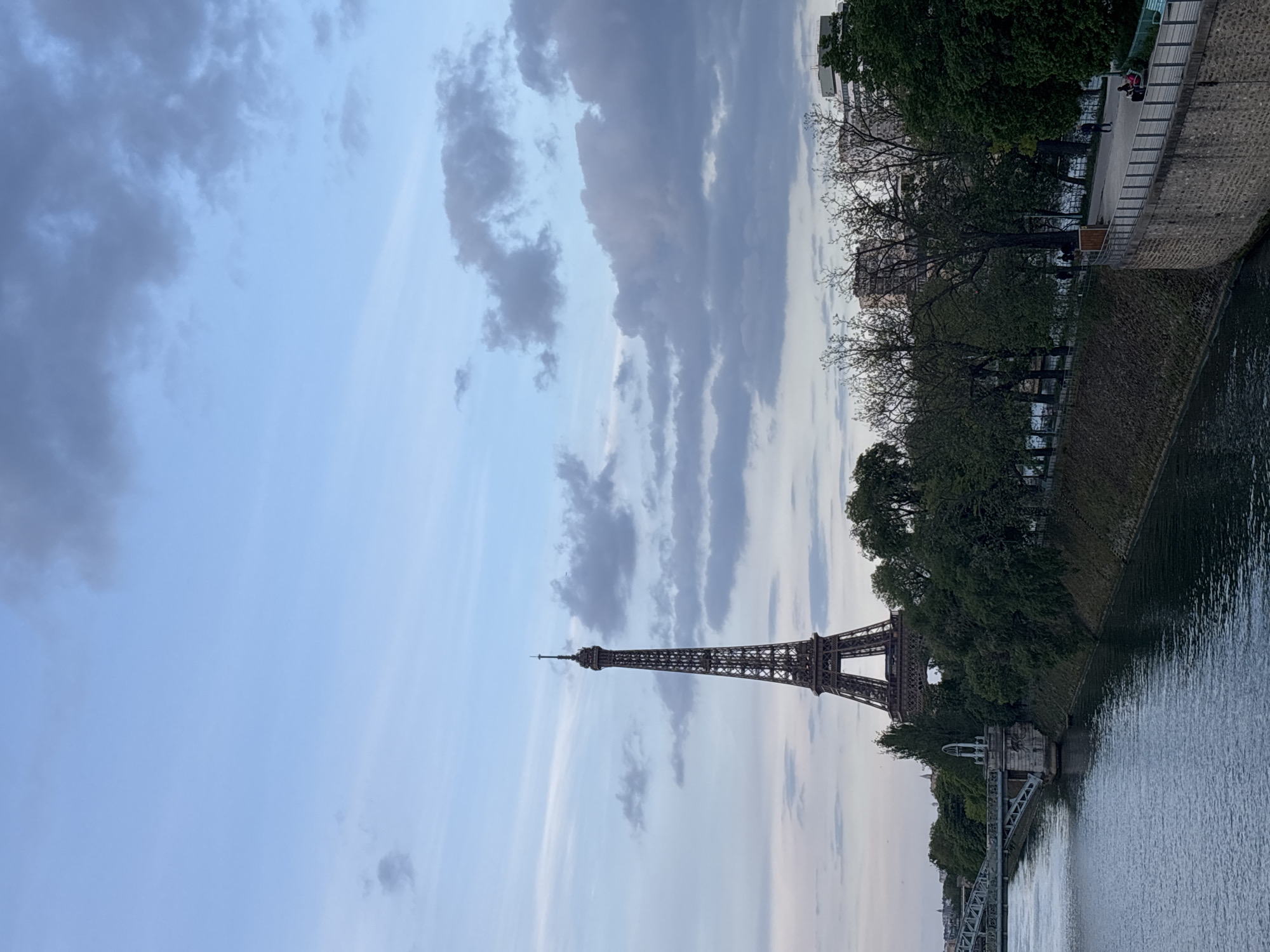 Eiffel Tower photographed from Seine River amid cloudy skies