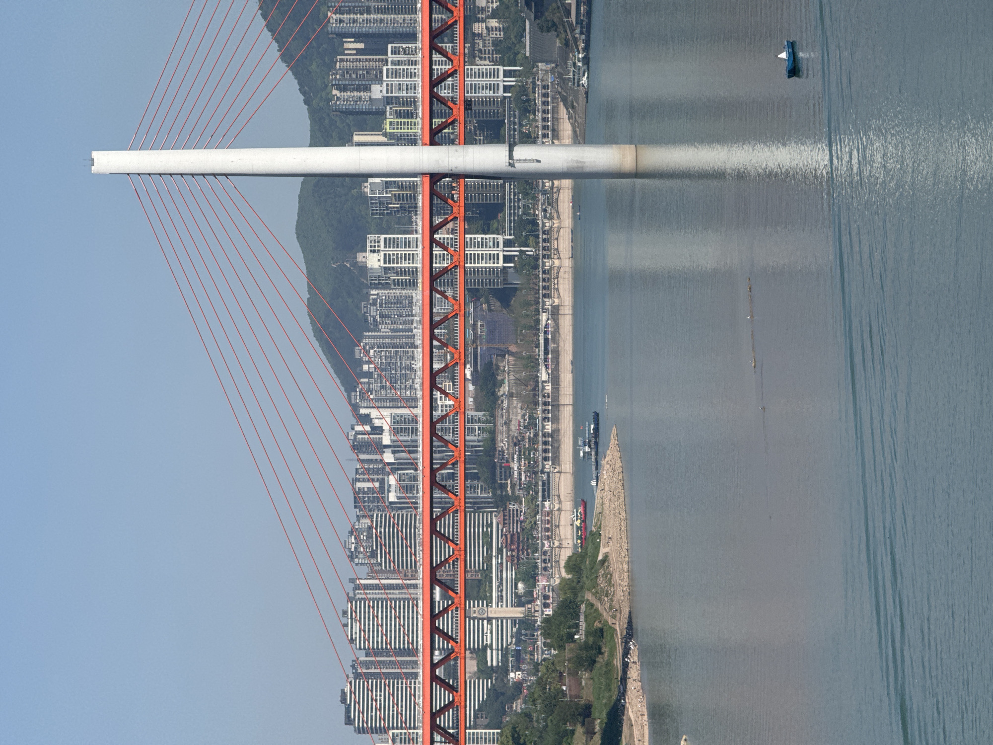 Clear day reveals Chongqing cityscape with river bridge