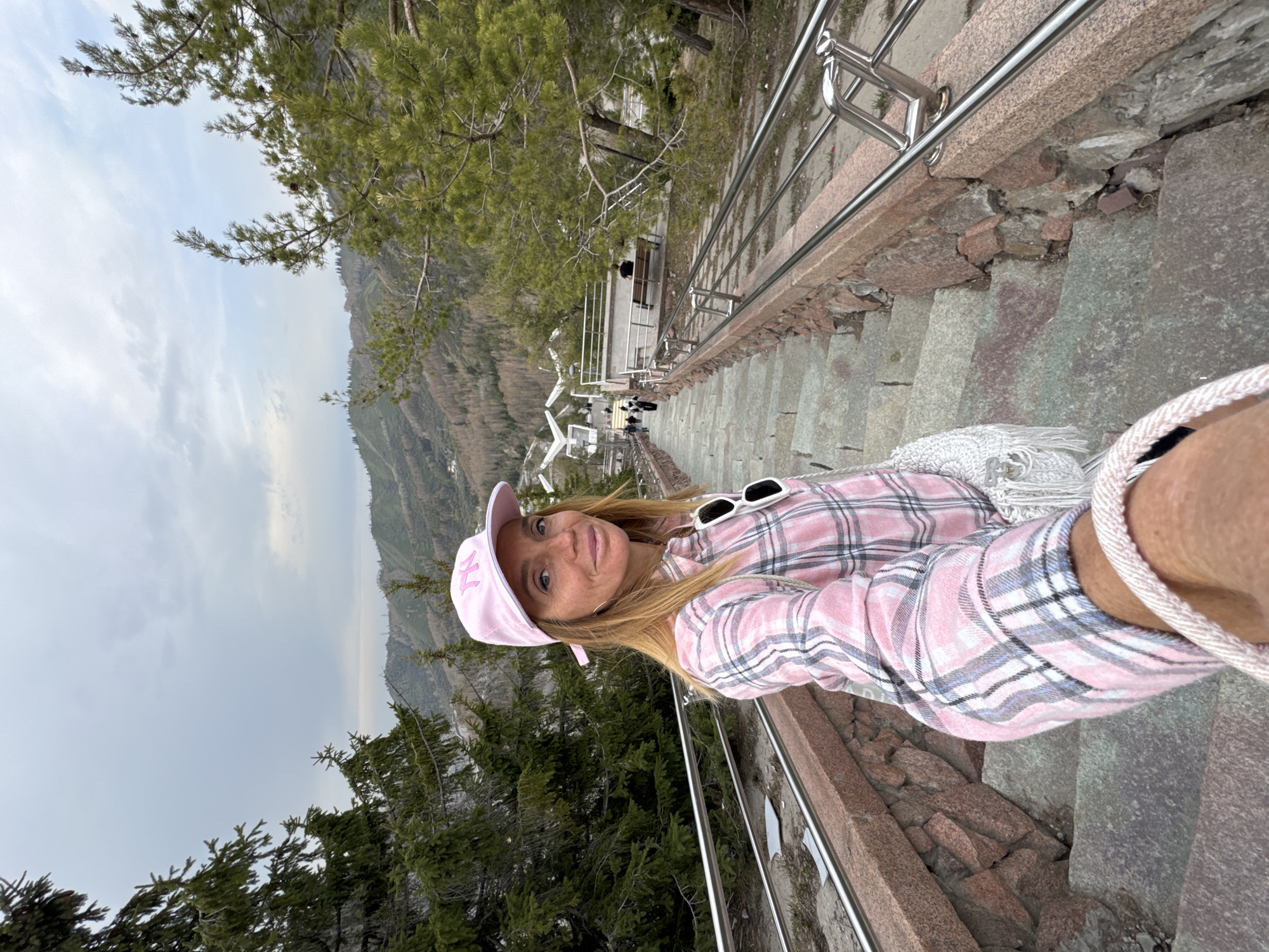 Woman takes selfie on mountain staircase in Almaty