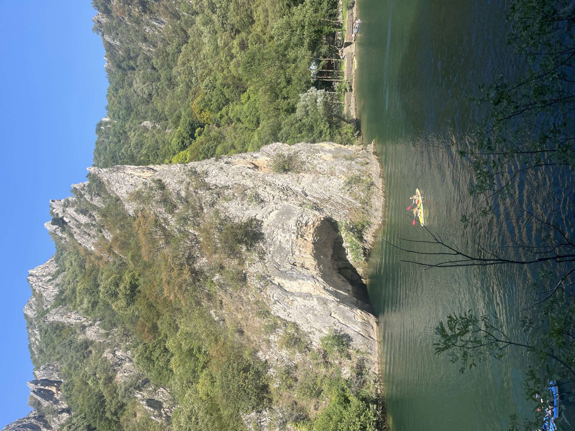 Remote river gorge with cliffs, caves, and dense forest