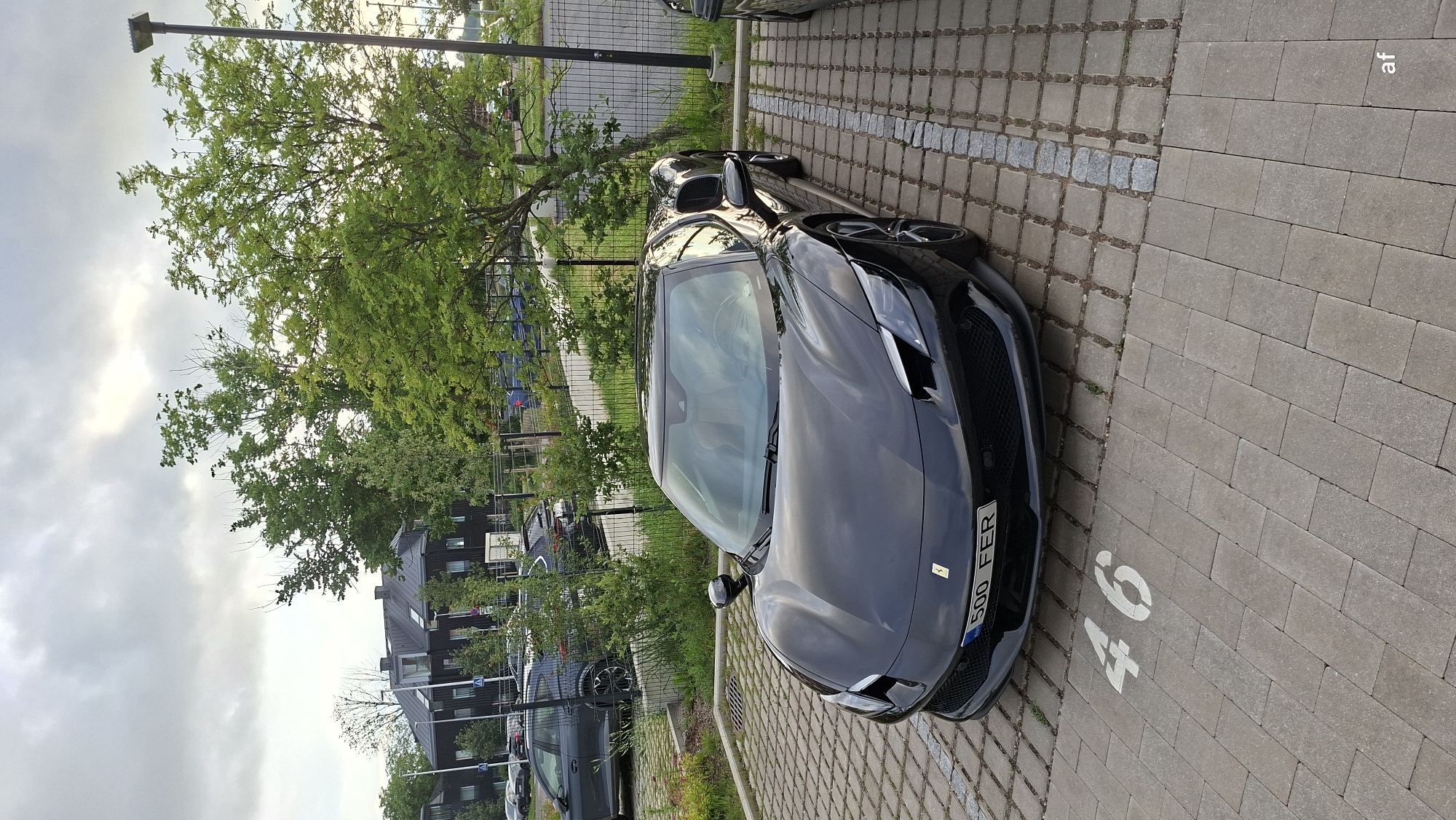 Black Ferrari parked on a numbered lot in Tallinn