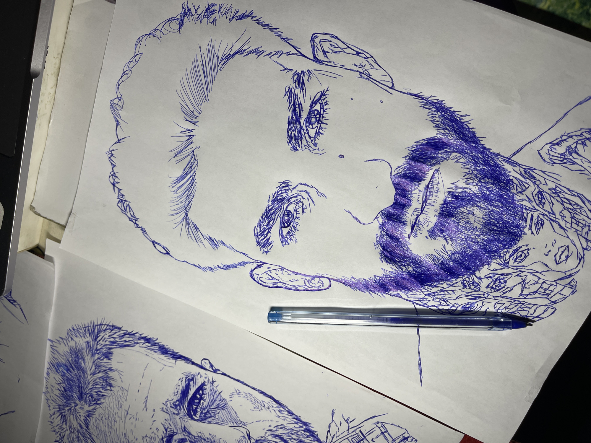 Blue ballpoint portrait sketches laid out in Jos