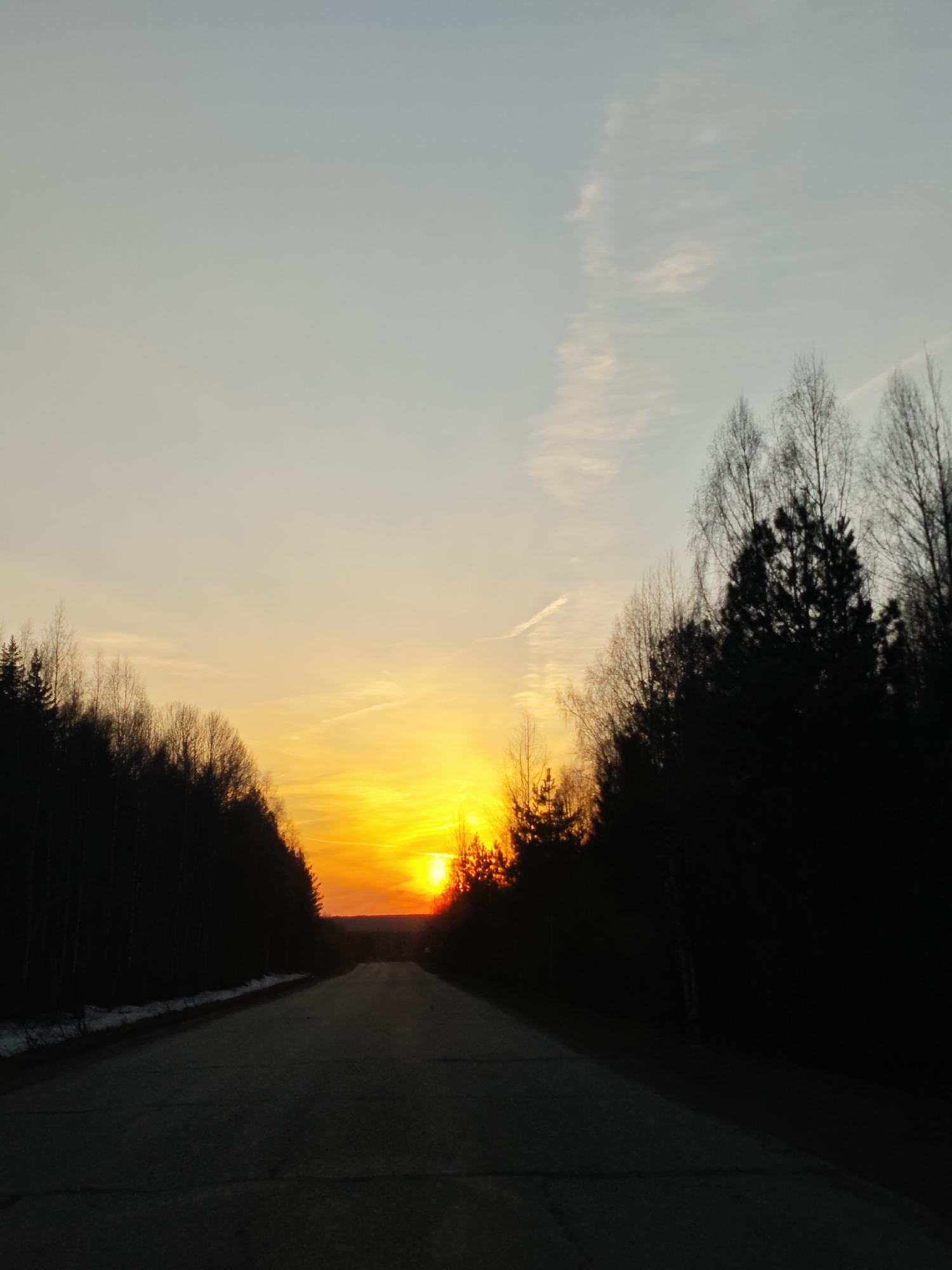 Sunset captured on tree-lined road in Markovo, Russia
