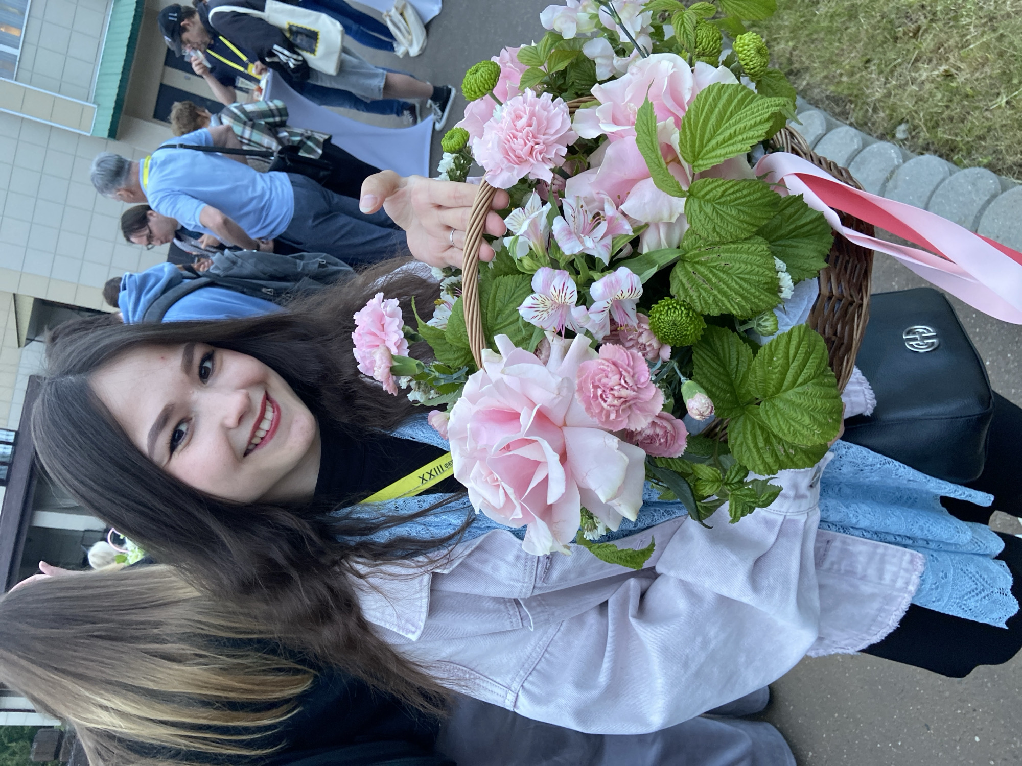 Woman with flowers attends outdoor gathering in Sergiyev Posad