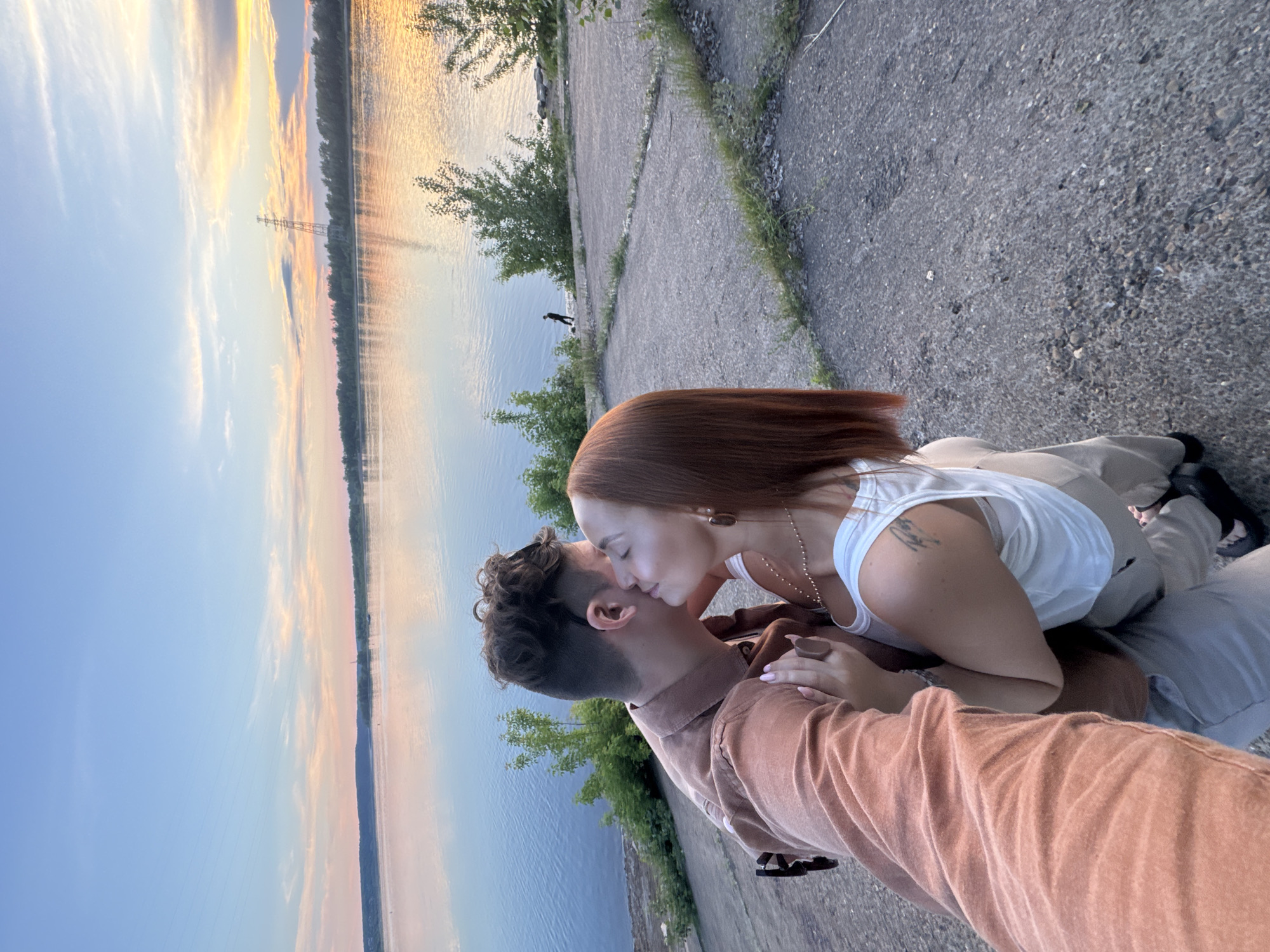 Couple shares romantic sunset moment by Russian riverside lighthouse