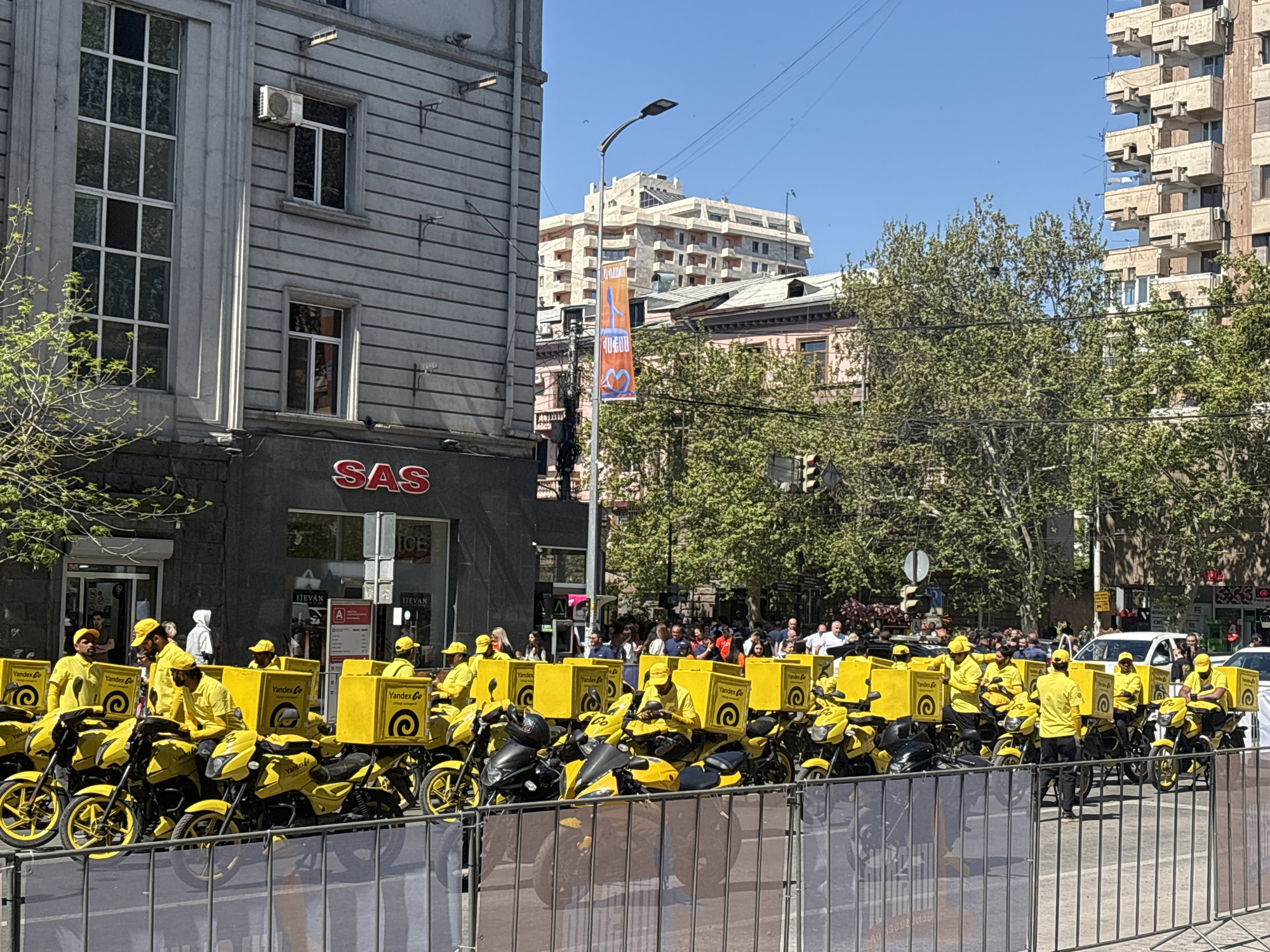 Yandex delivery drivers gather in yellow uniforms on Yerevan street