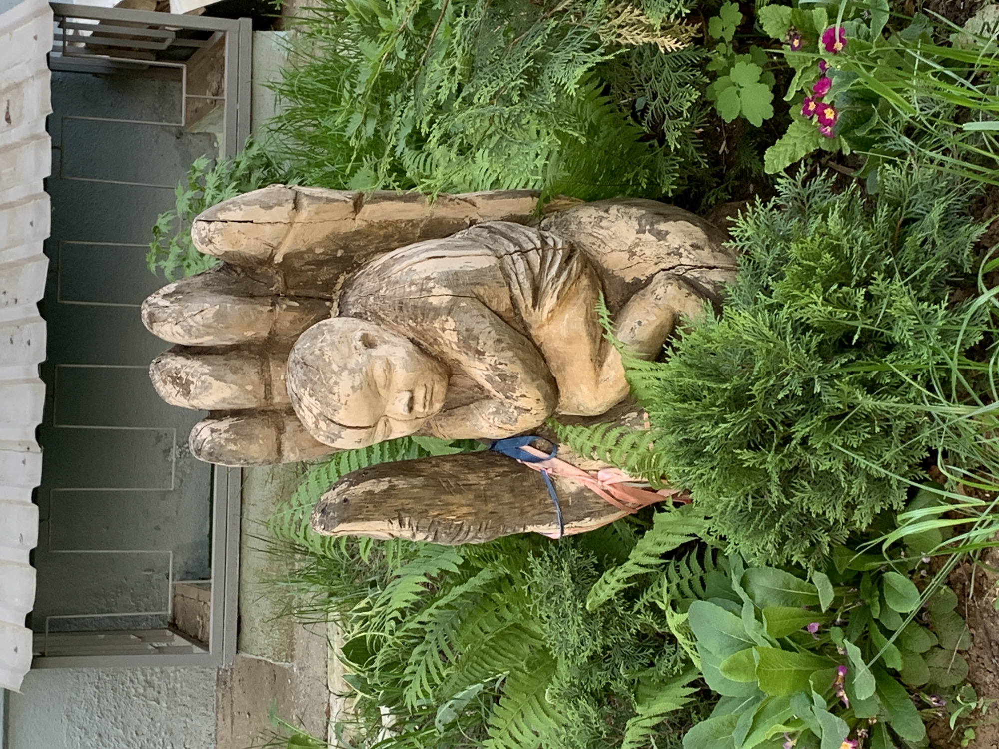 Sleeping figure sculpture observed in landscaped area, Chaikovsky