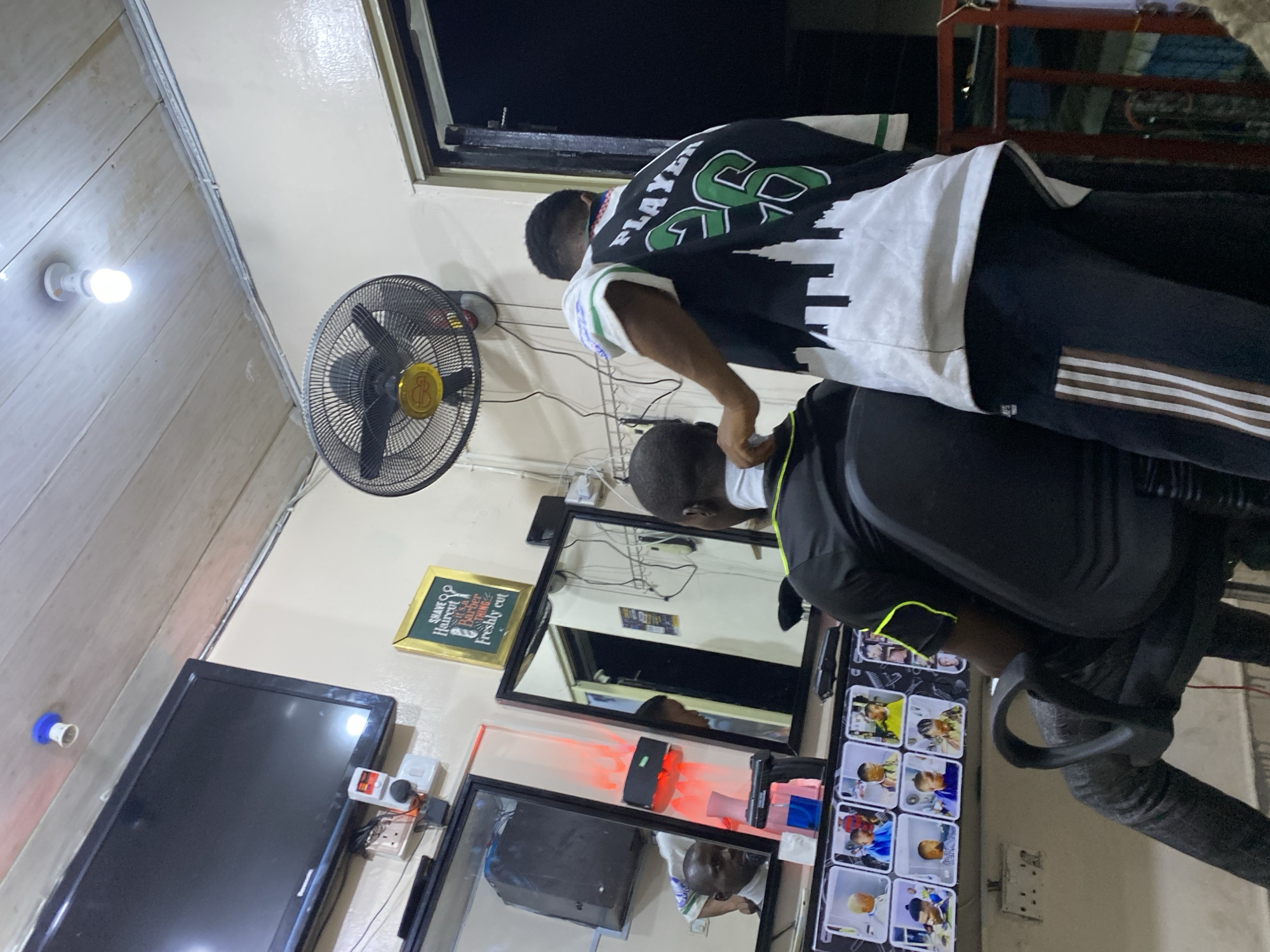 Evening haircut session documented at Ado Nigeria barbershop