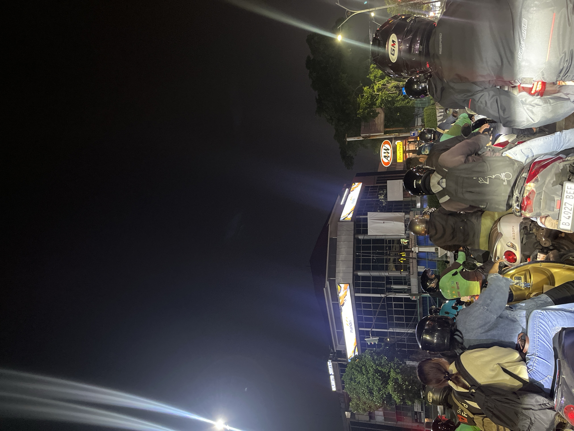 Motorcyclists caught in nighttime traffic jam in West Jakarta