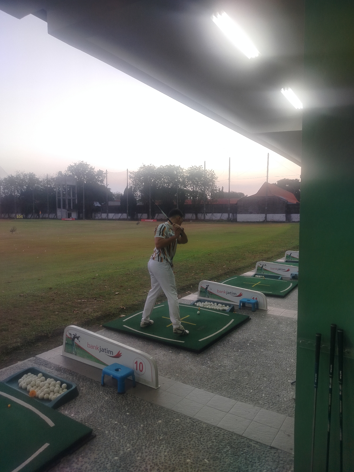 Afternoon at a Surabaya driving range, multiple bays in use