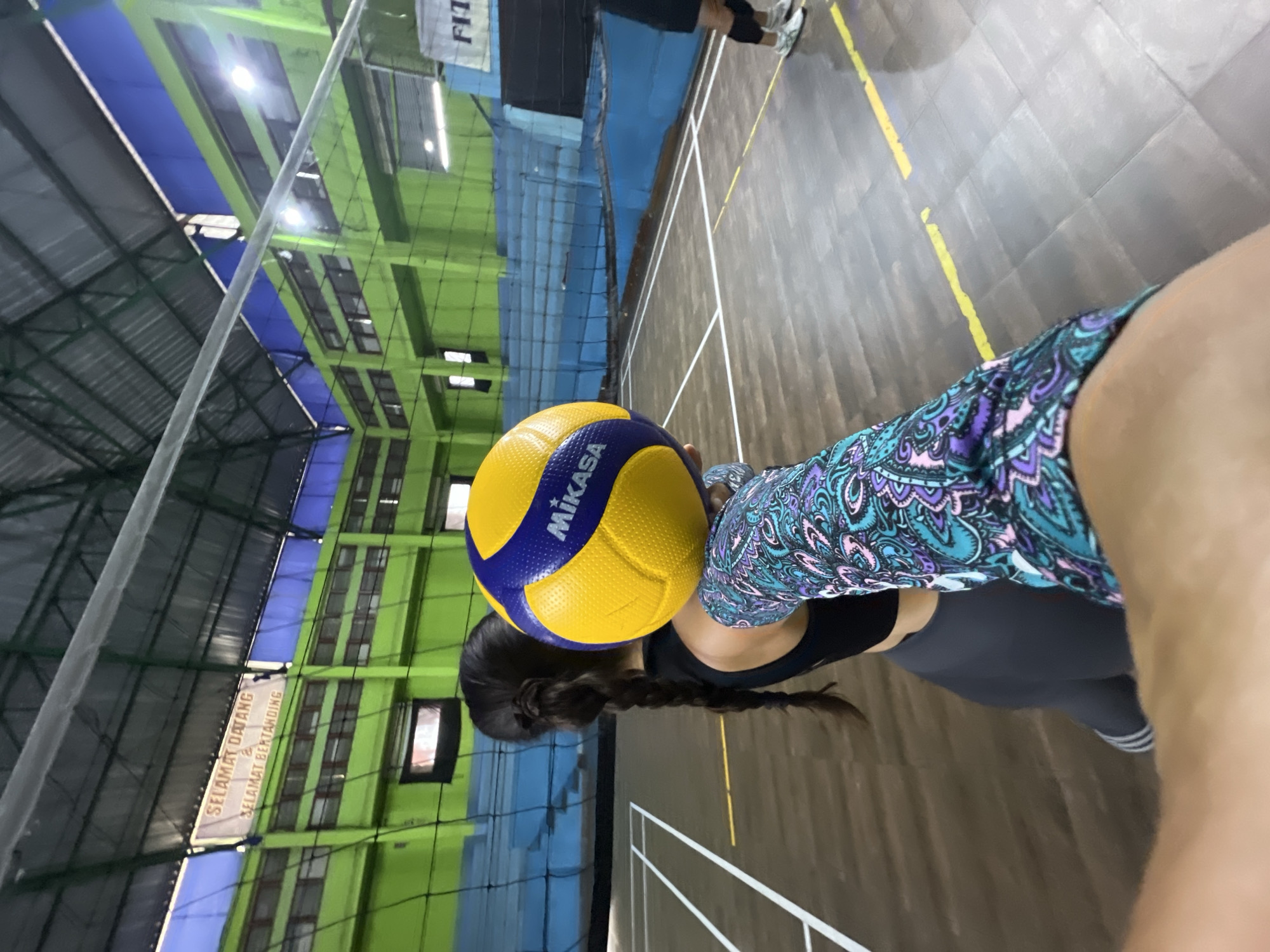 Woman holds volleyball indoors in Ubud District