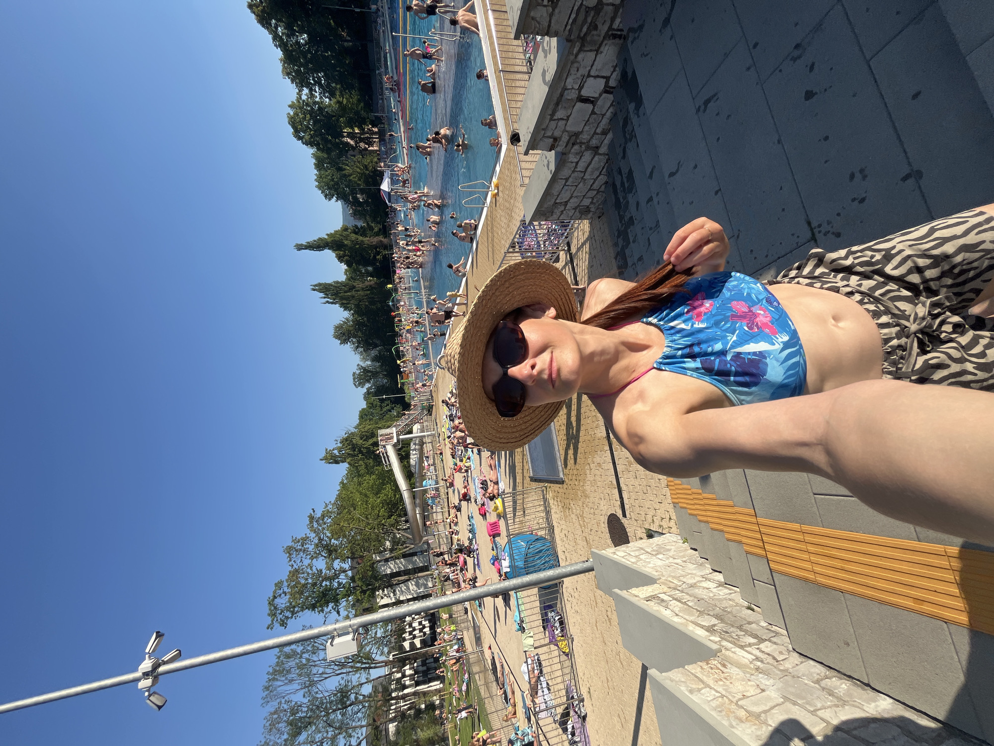 Crowded outdoor pool on a bright summer afternoon