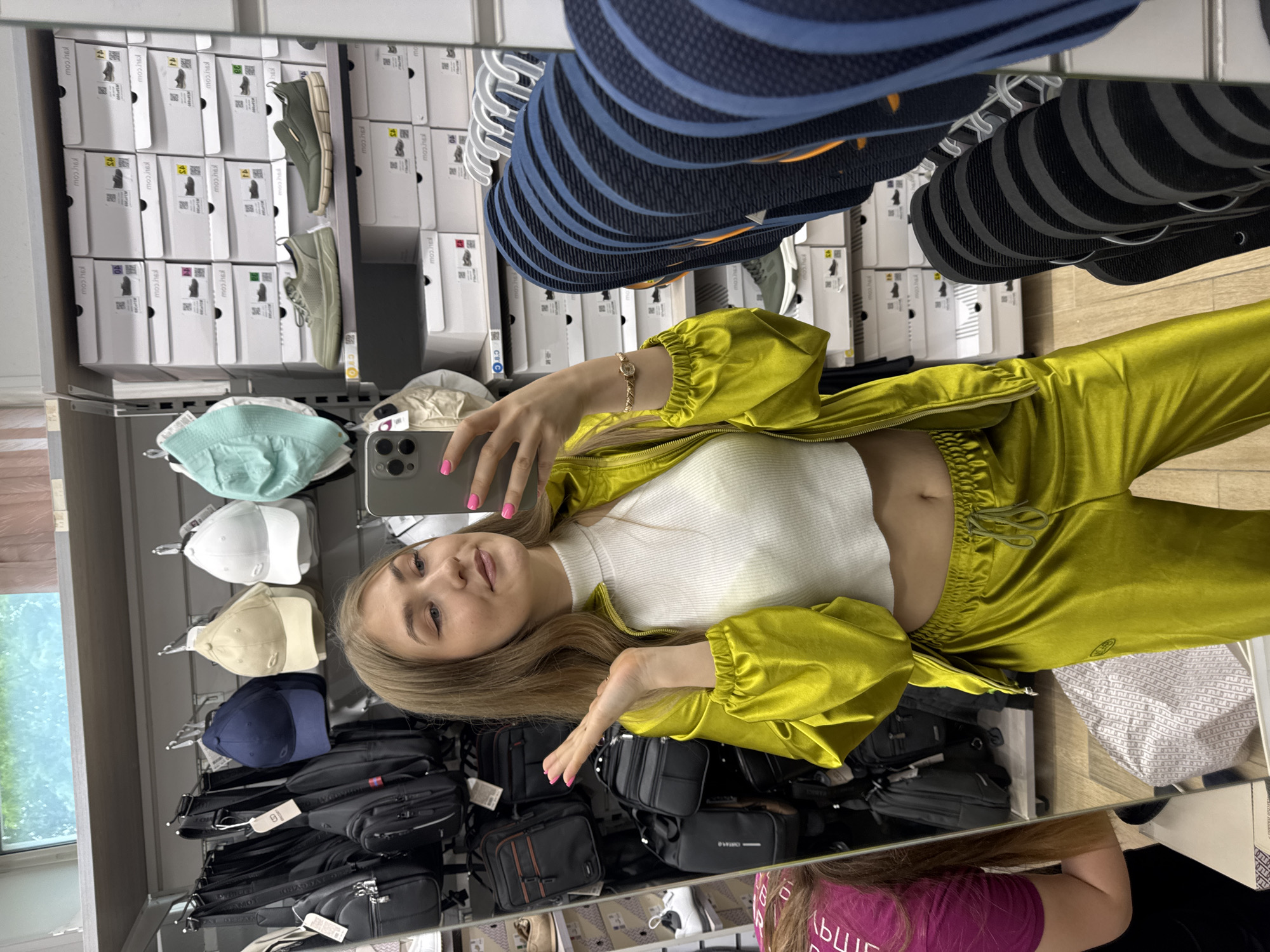 Woman takes mirror selfies in tracksuit at Ussurijsk store