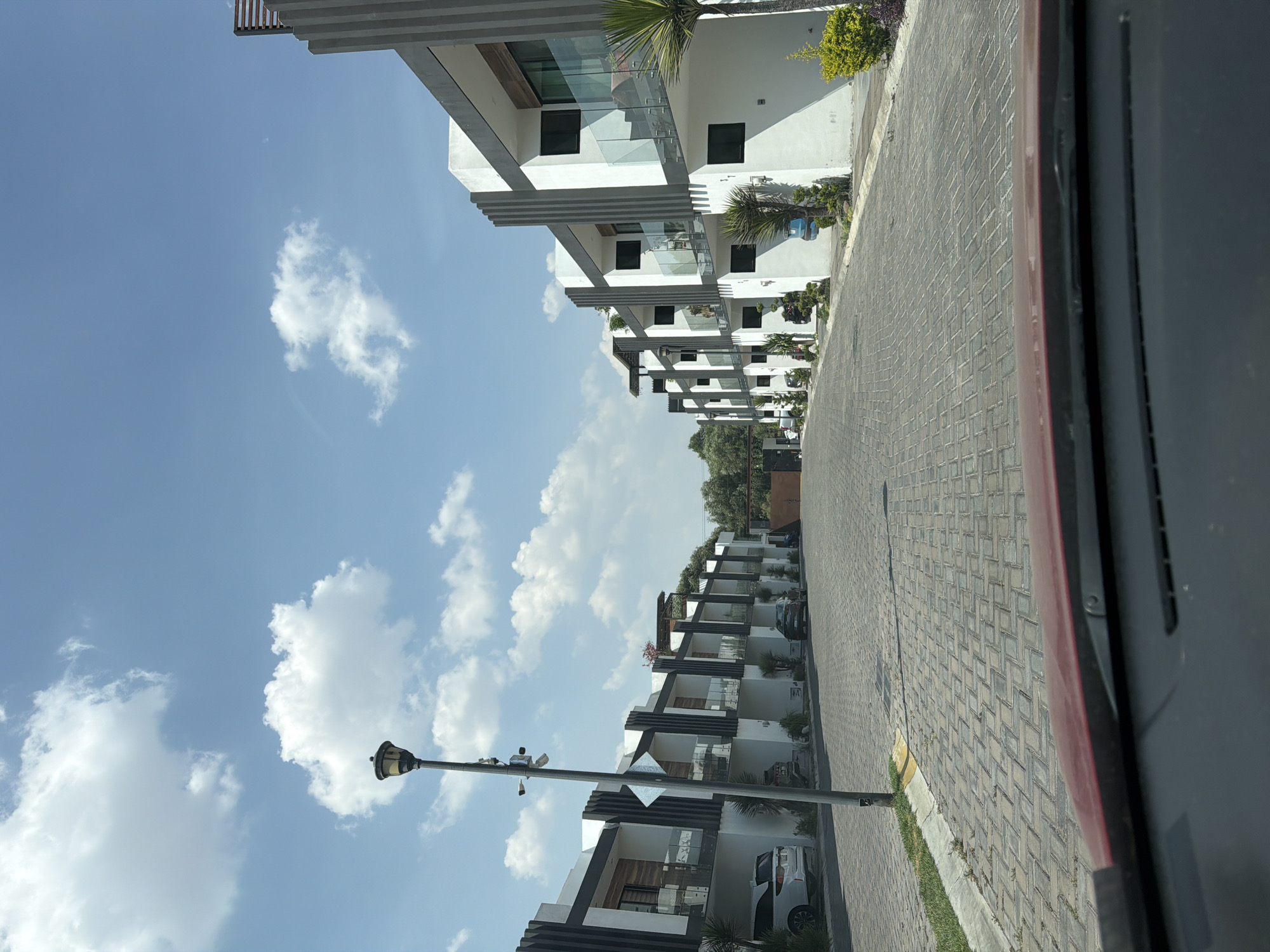 Vehicle occupant observes paved residential street in Cholula, Mexico