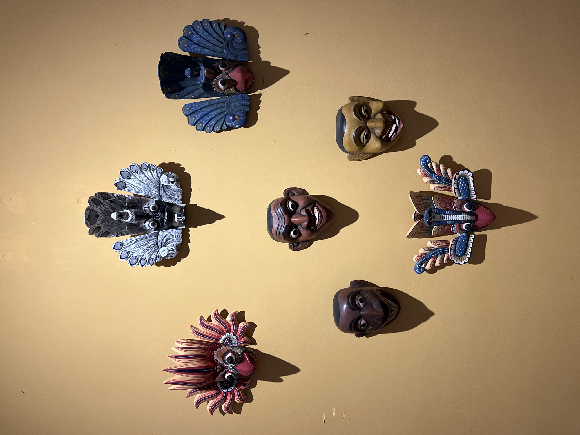 Traditional Sri Lankan masks displayed on wall in Galle