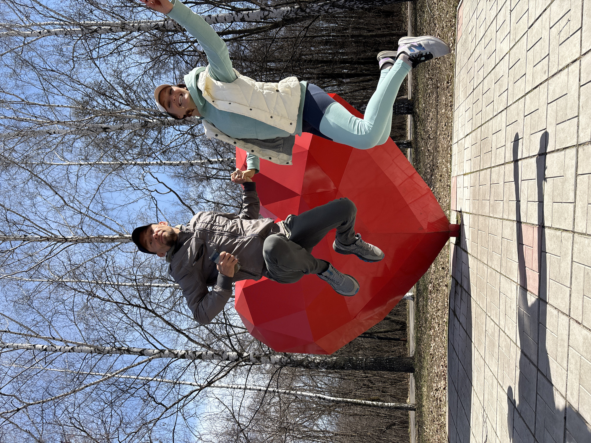 Couple poses at red heart sculpture in Ulyanovsk park