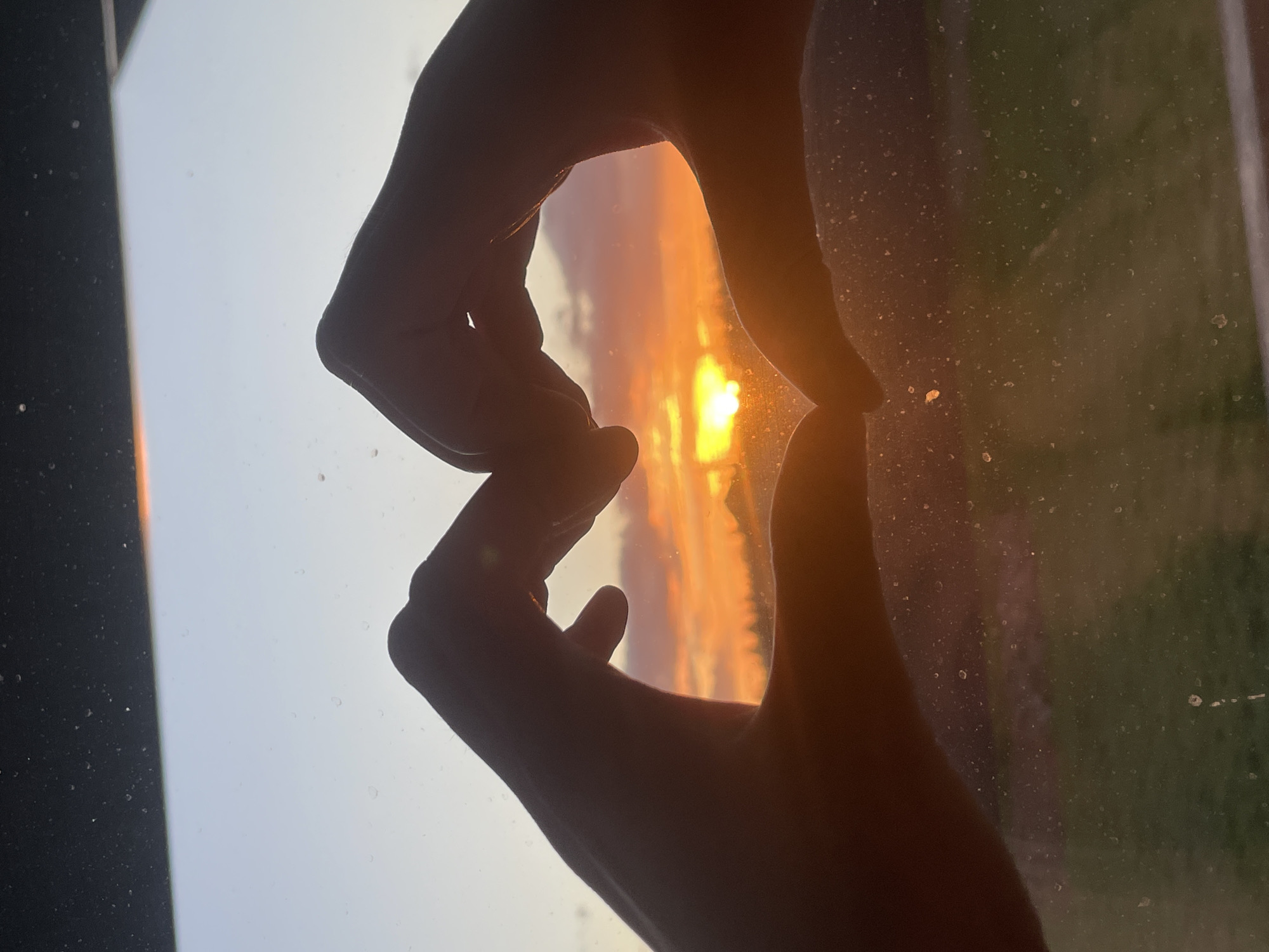 Sunset framed by hands through window in Russian village