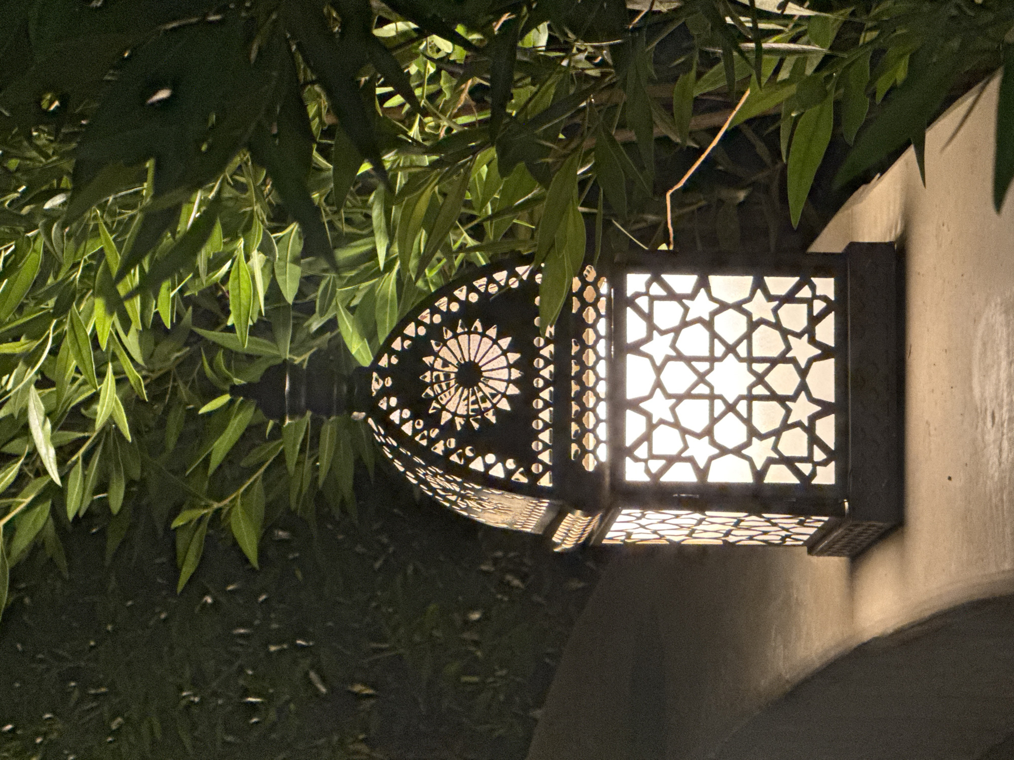 Geometric metal lanterns glowing on a concrete ledge at night