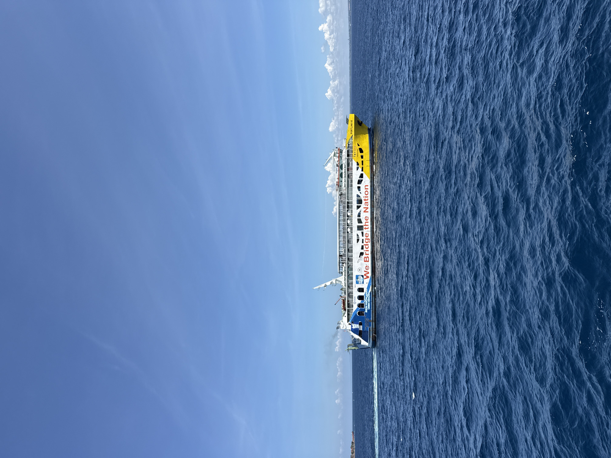 Ferry sails near Melaya coast under clear skies